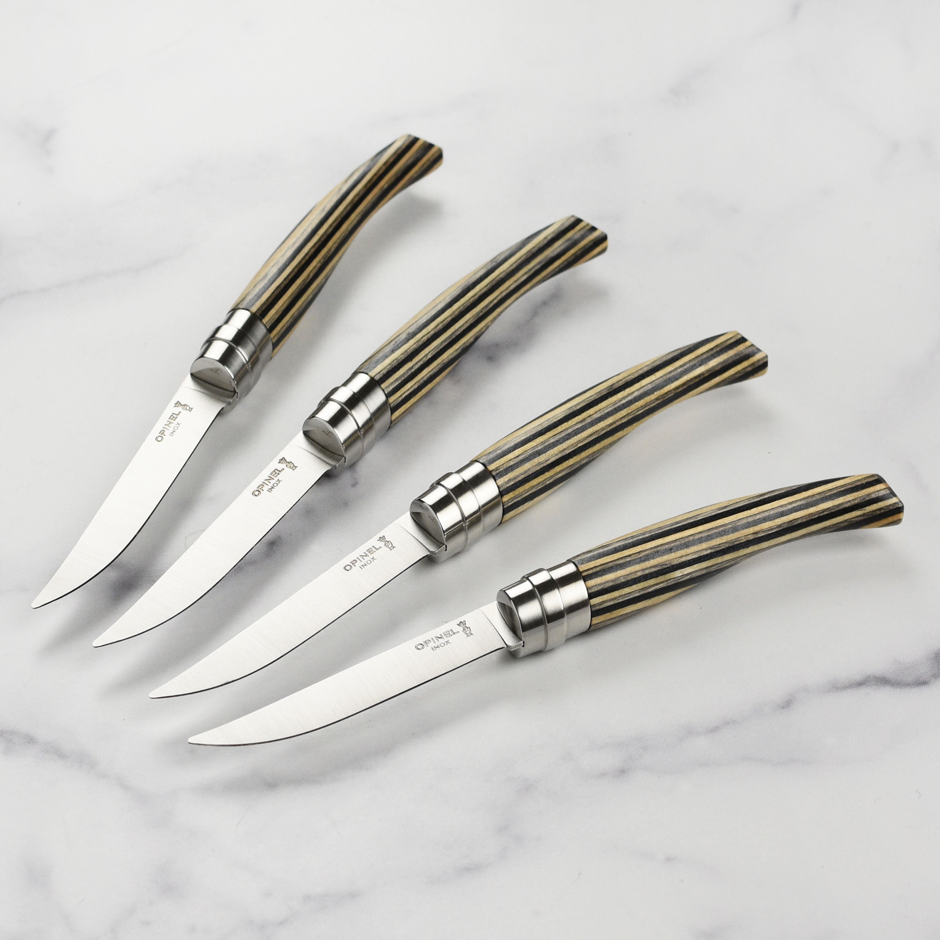 Close-up view of premium birchwood handle steak knives on a dining table.