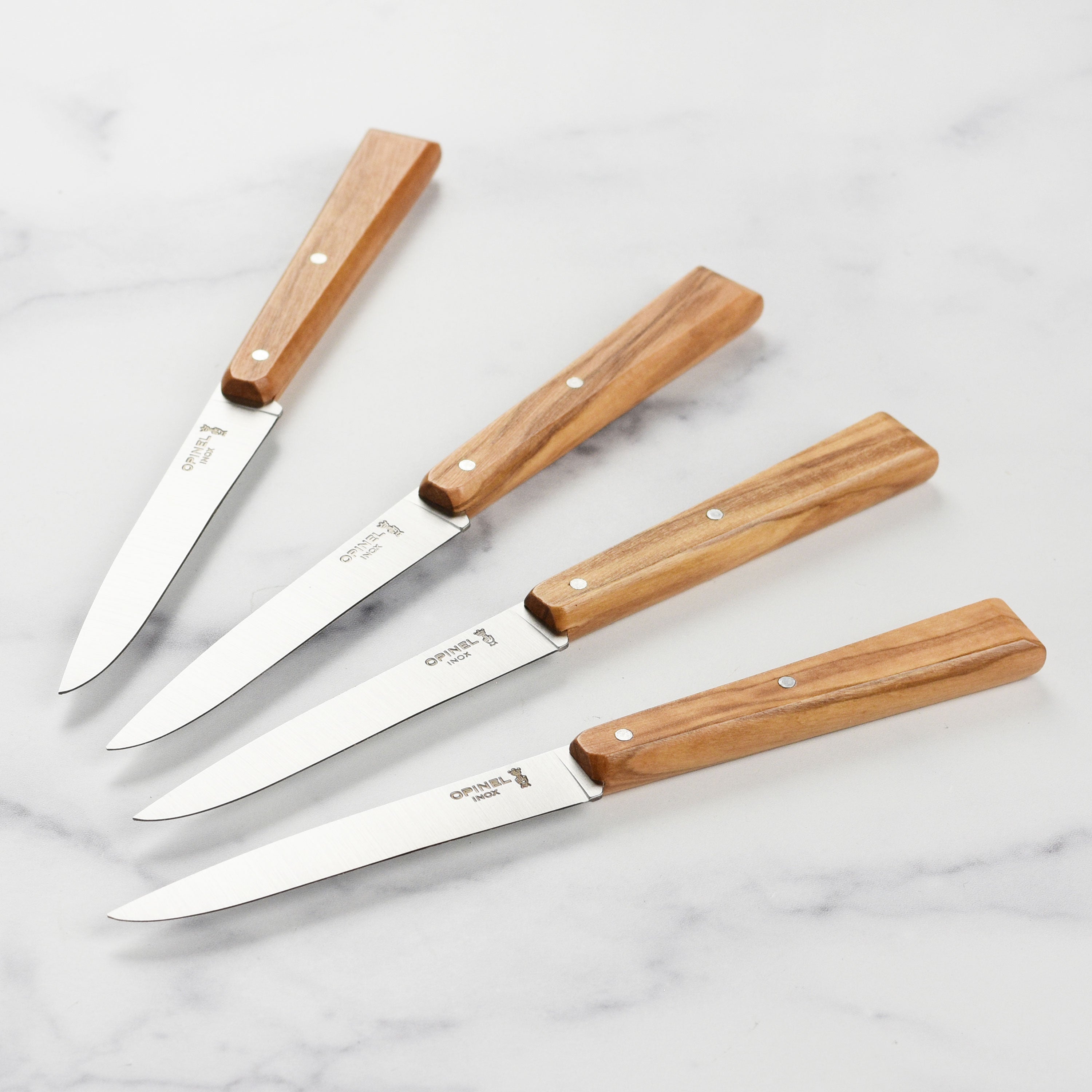 Close-up of the olive wood steak knives showcasing their ergonomic handles.