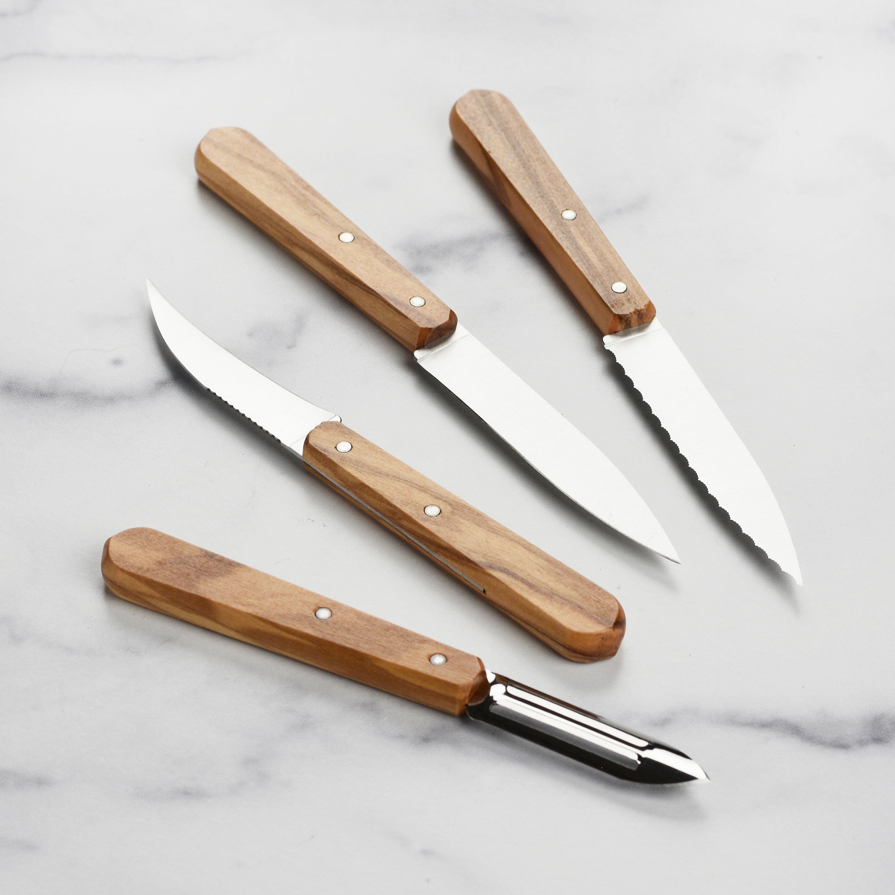 Close-up of stainless steel peeling knife with olive wood handle showing its sharp blade