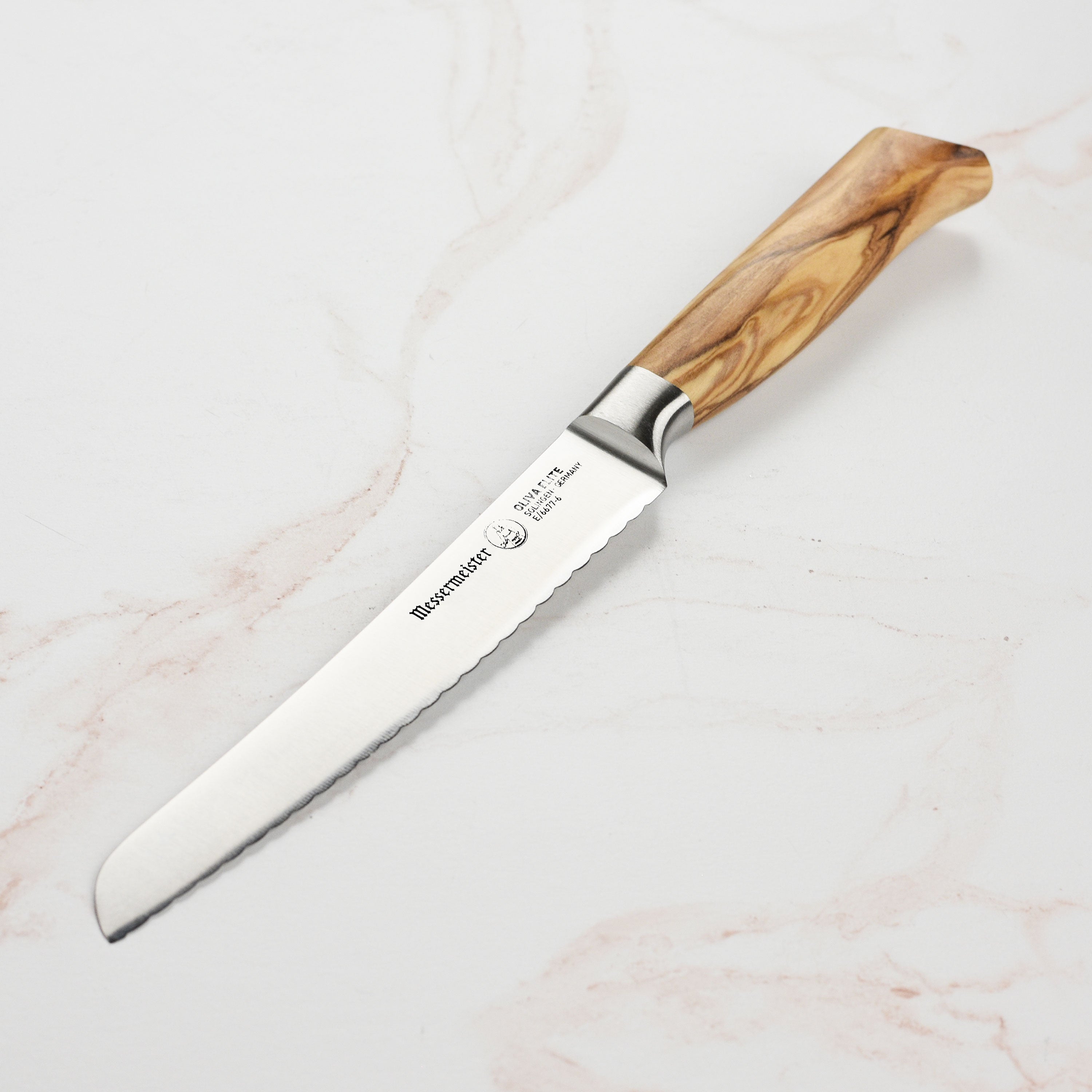 Close-up of Messermeister Oliva Elite serrated utility knife with ergonomic olive wood handle