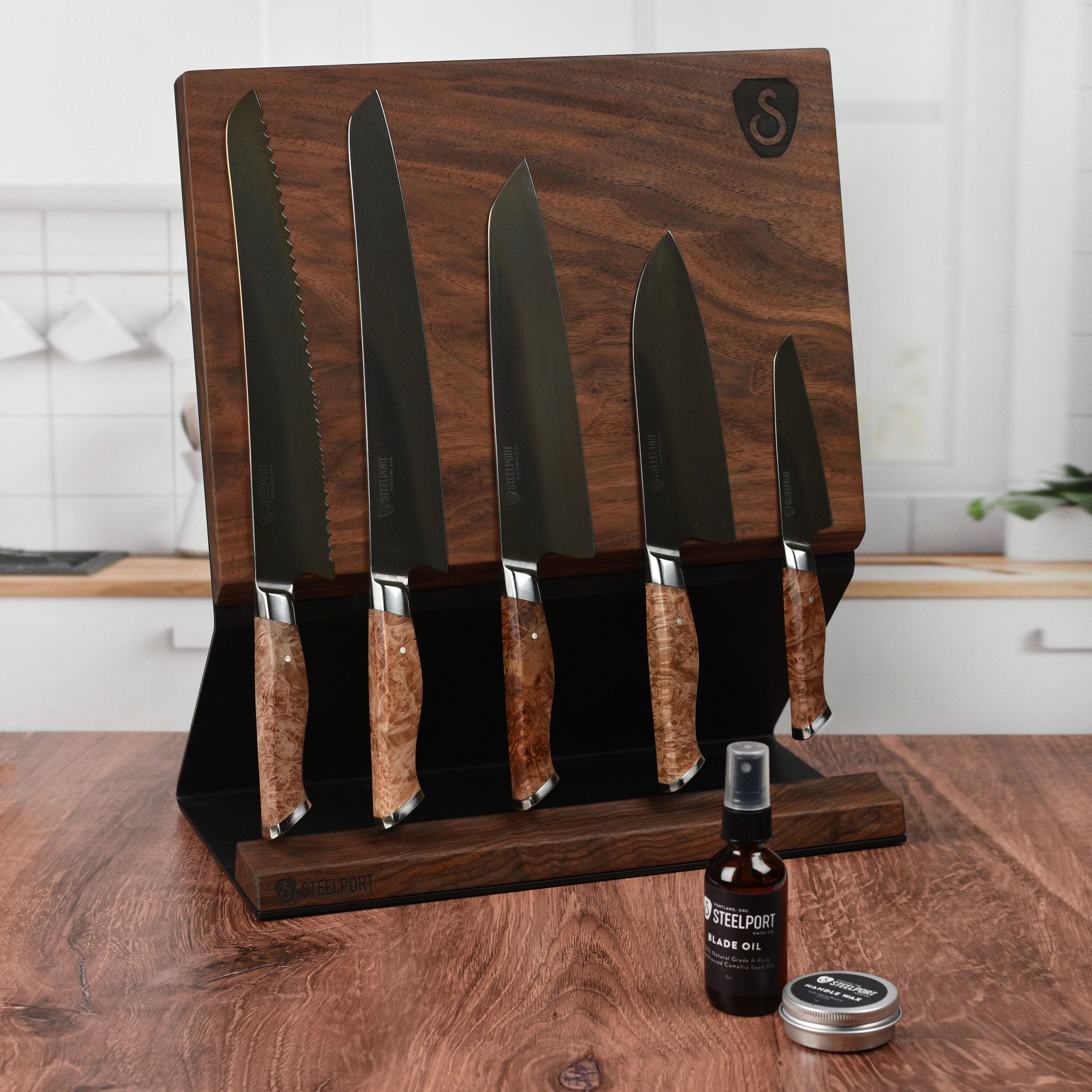 Close-up of Steelport carbon steel chef knife with magnetic block in kitchen setting.