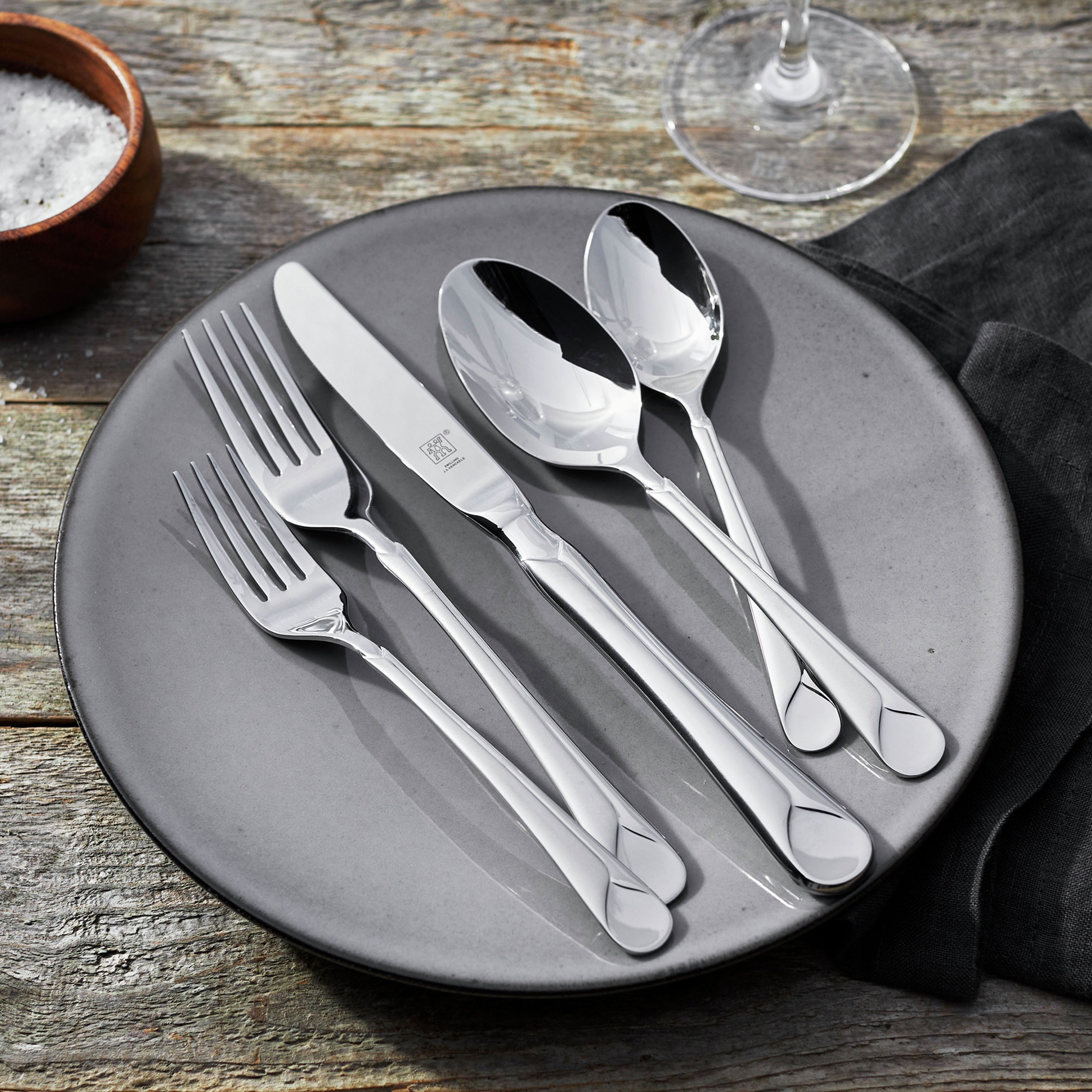 Close-up of stainless steel flatware set with dinner and salad forks, highlighting European design