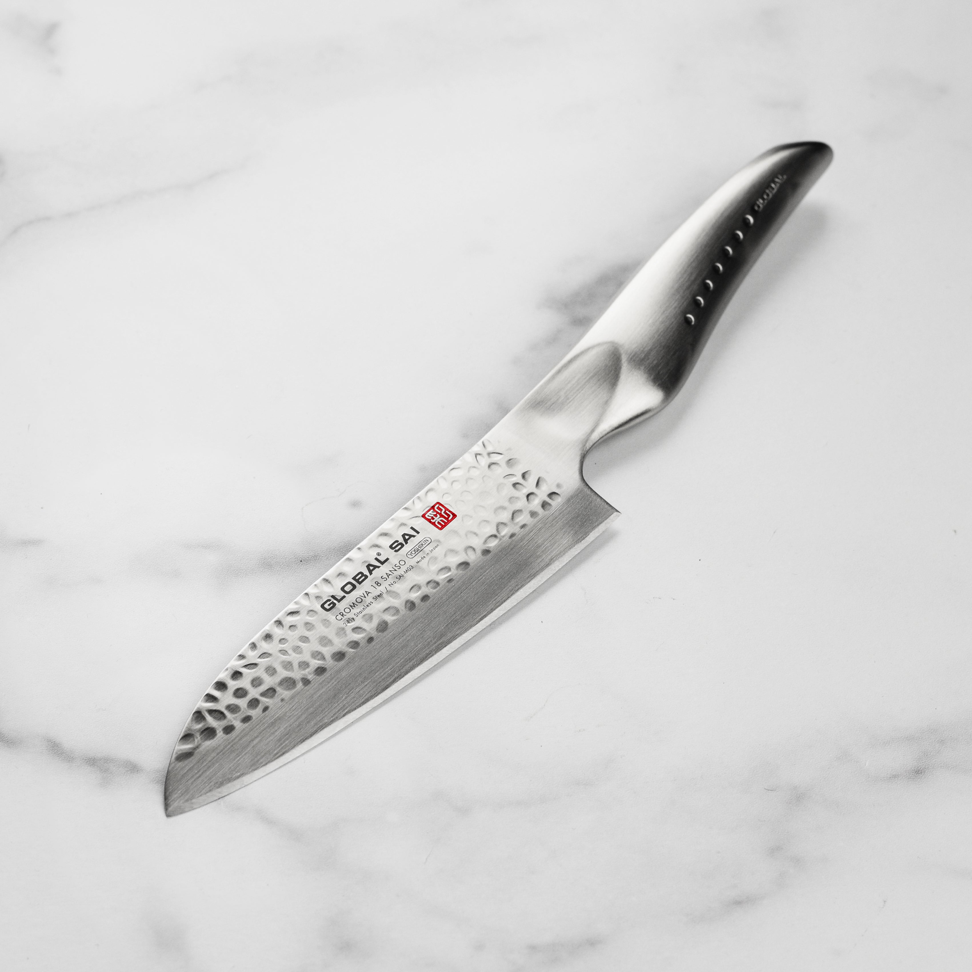 Japanese Santoku knife with hand-hammered blade and ergonomic handle for precision slicing