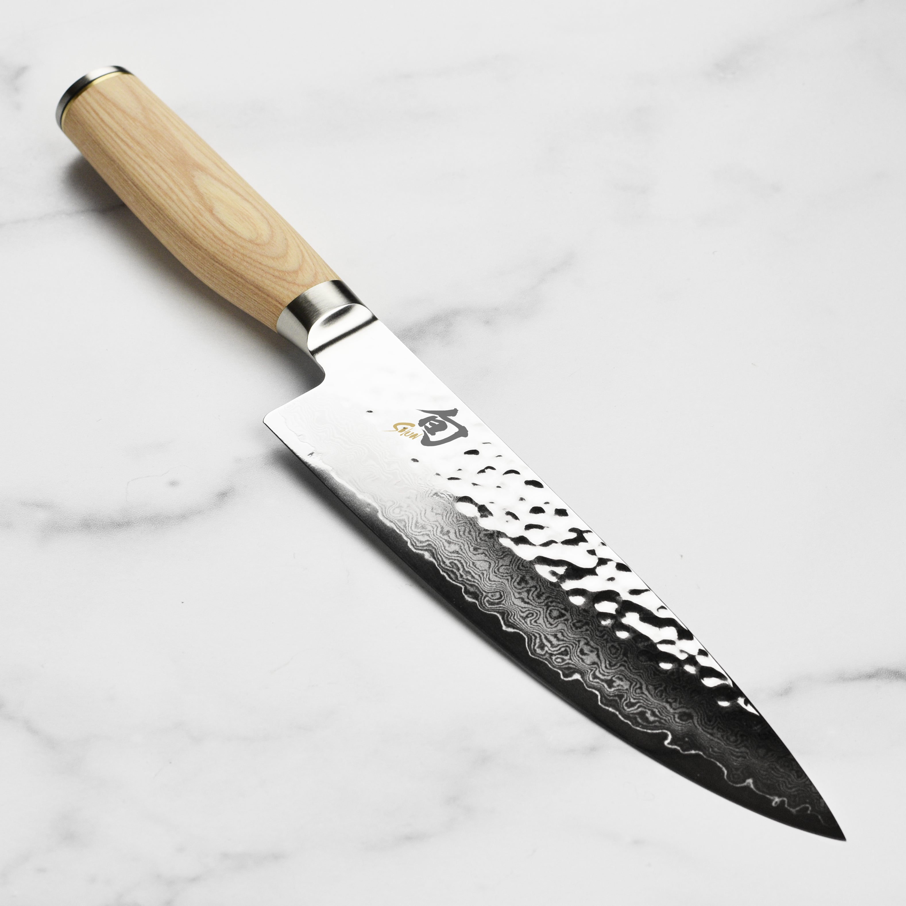 Shun Premier Blonde 8-Inch Chef Knife with a sleek blade design on a wooden cutting board.