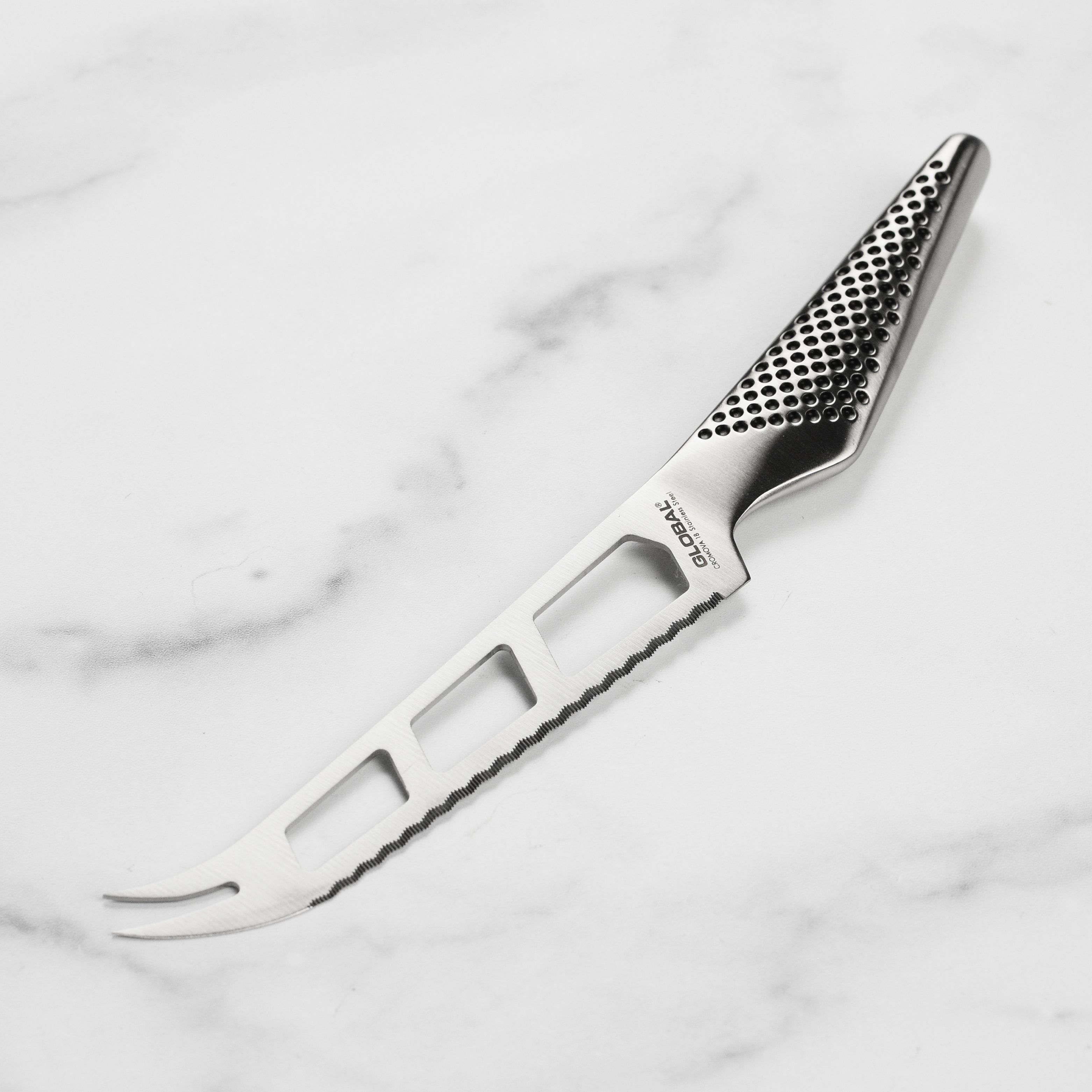 Close-up of the Premium Japanese Soft Cheese Knife showcasing the serrated edge and dimpled handle.