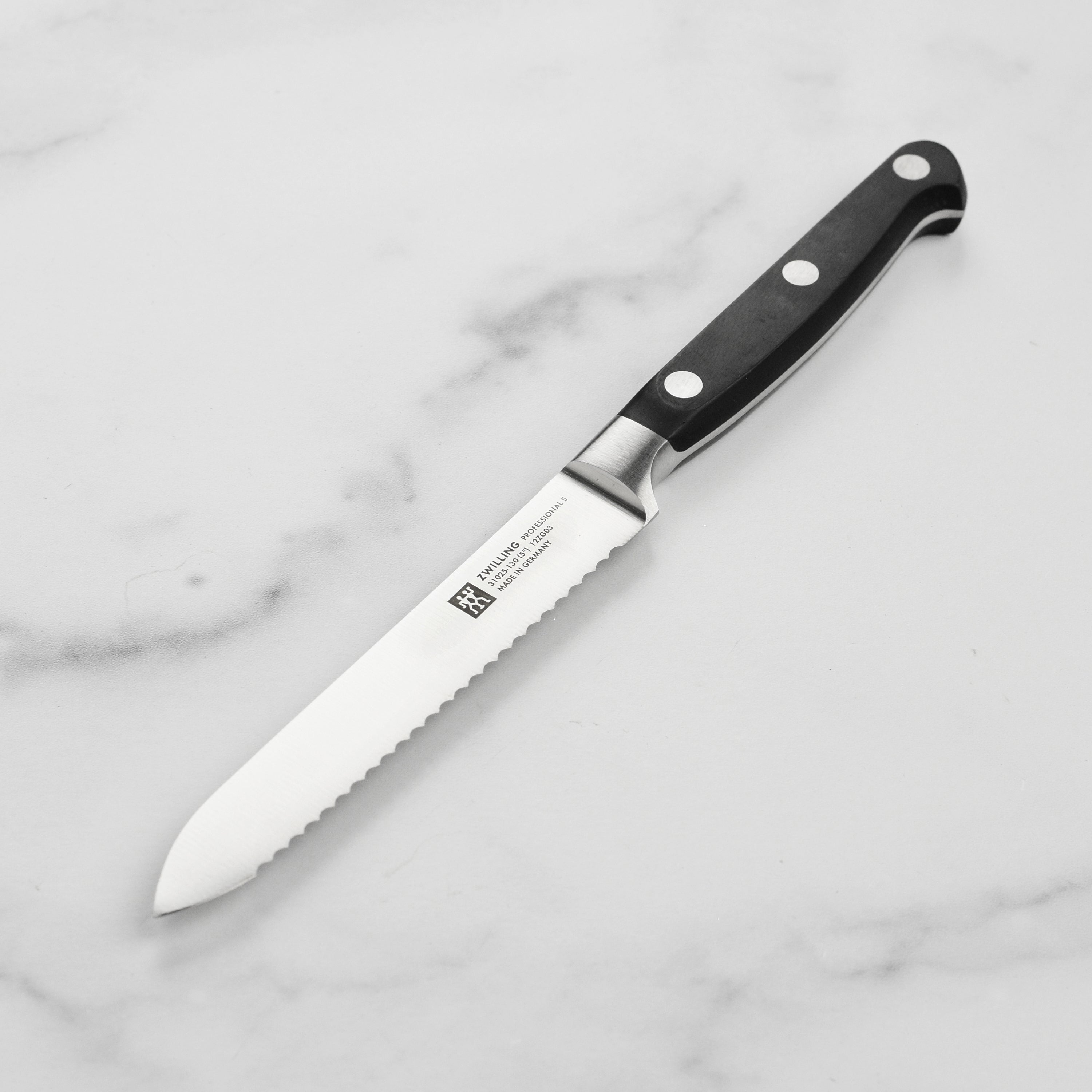 Close-up of Zwilling Professional utility knife cutting bread
