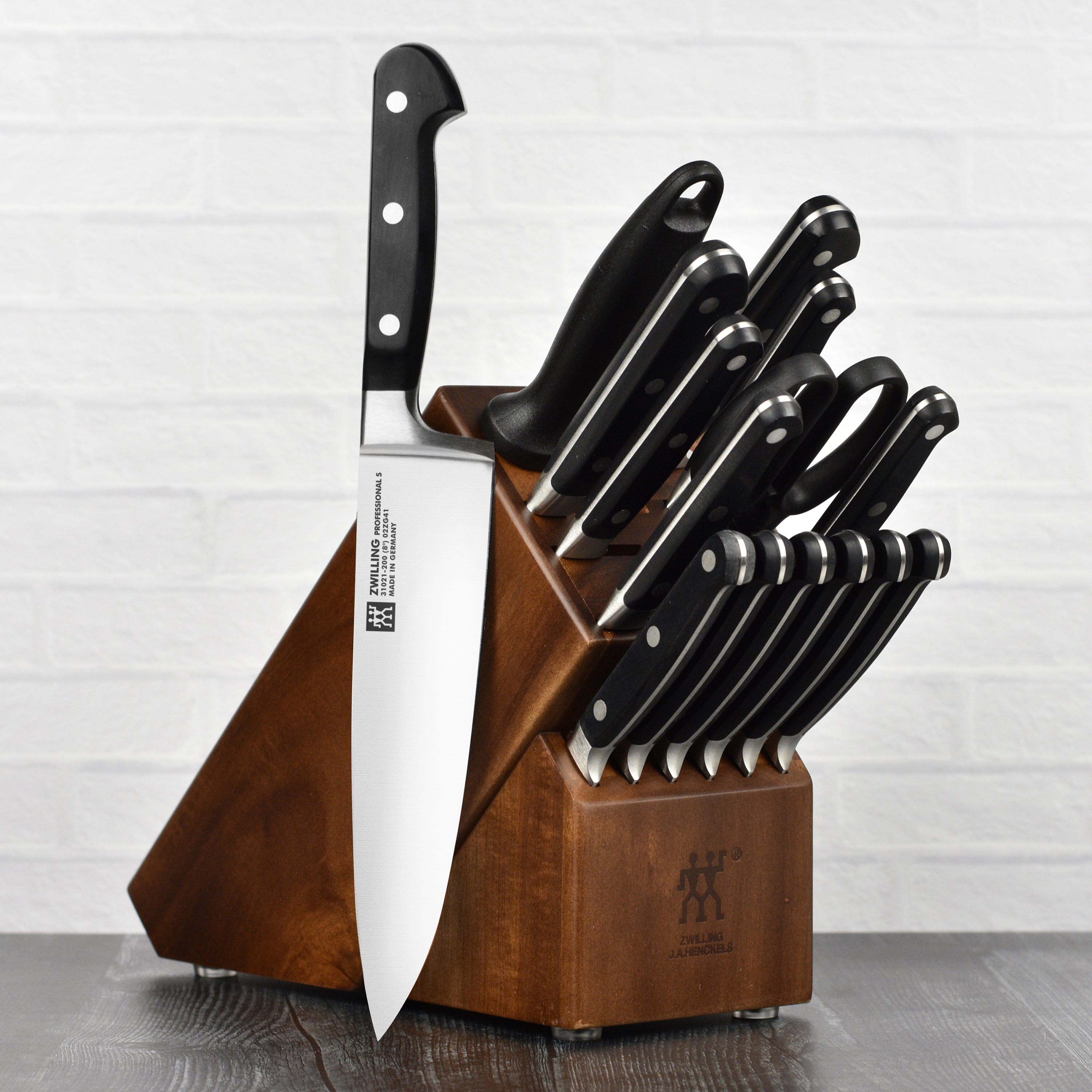 Close-up of Zwilling professional kitchen knives with high carbon stainless steel blades in acacia block