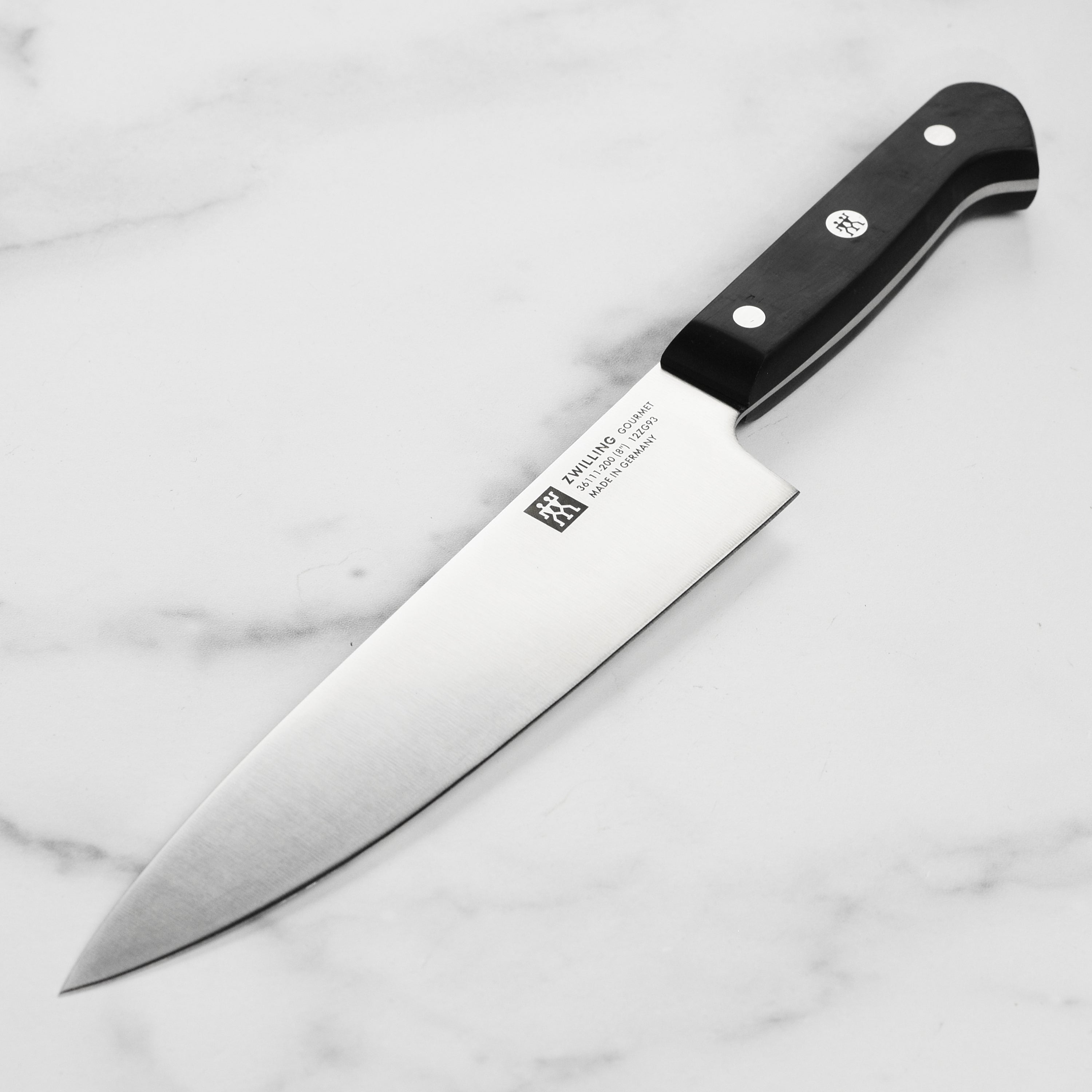 Close-up view of the Zwilling Gourmet 8-inch chef's knife showcasing its precision-honed high-carbon stainless steel blade.