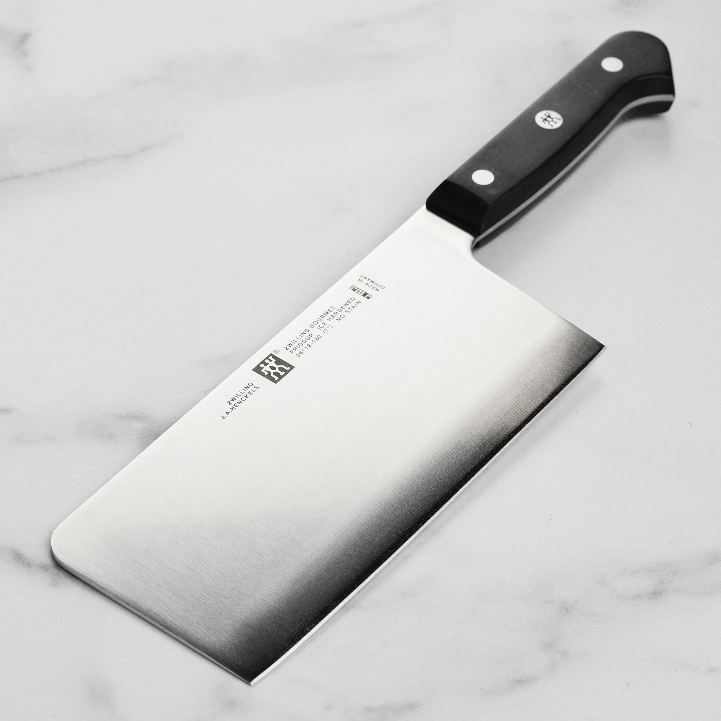 Close-up of Zwilling Gourmet high-carbon steel knife blade with laser-honed edge for slicing vegetables.
