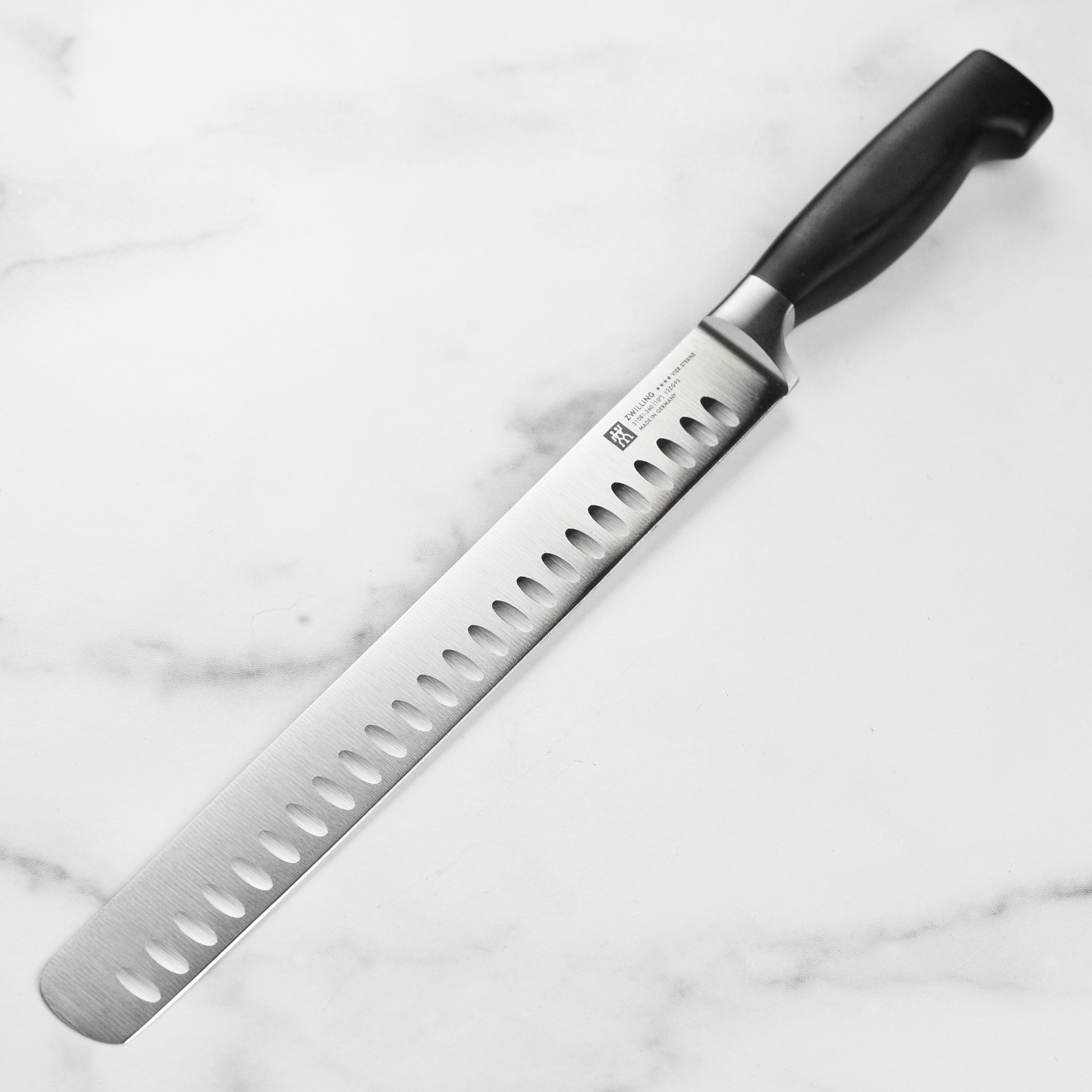 Close-up of Zwilling Four Star slicing knife showing the sharp edge and full tang design.
