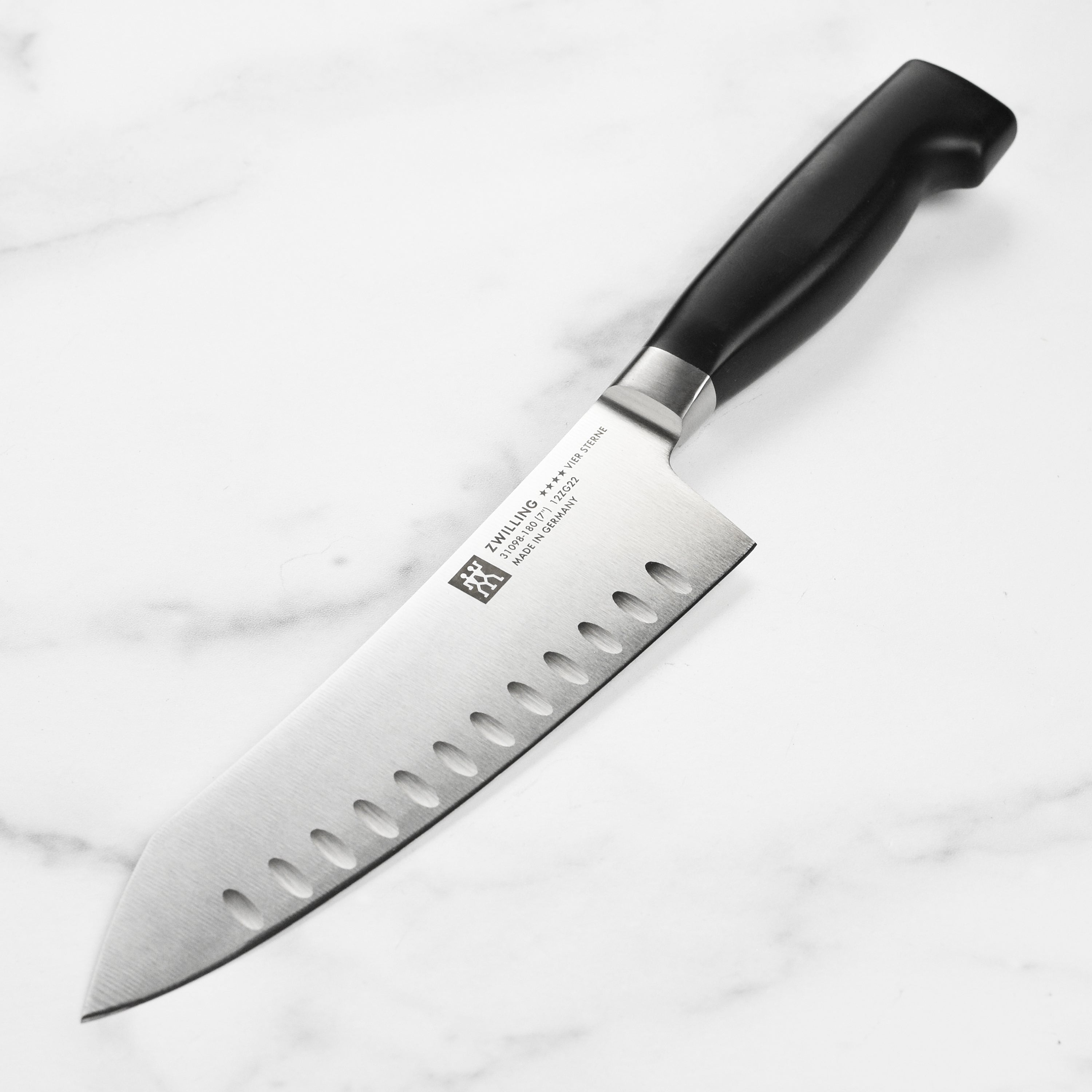 Zwilling Four Star Santoku knife showing sharp blade and ergonomic handle.