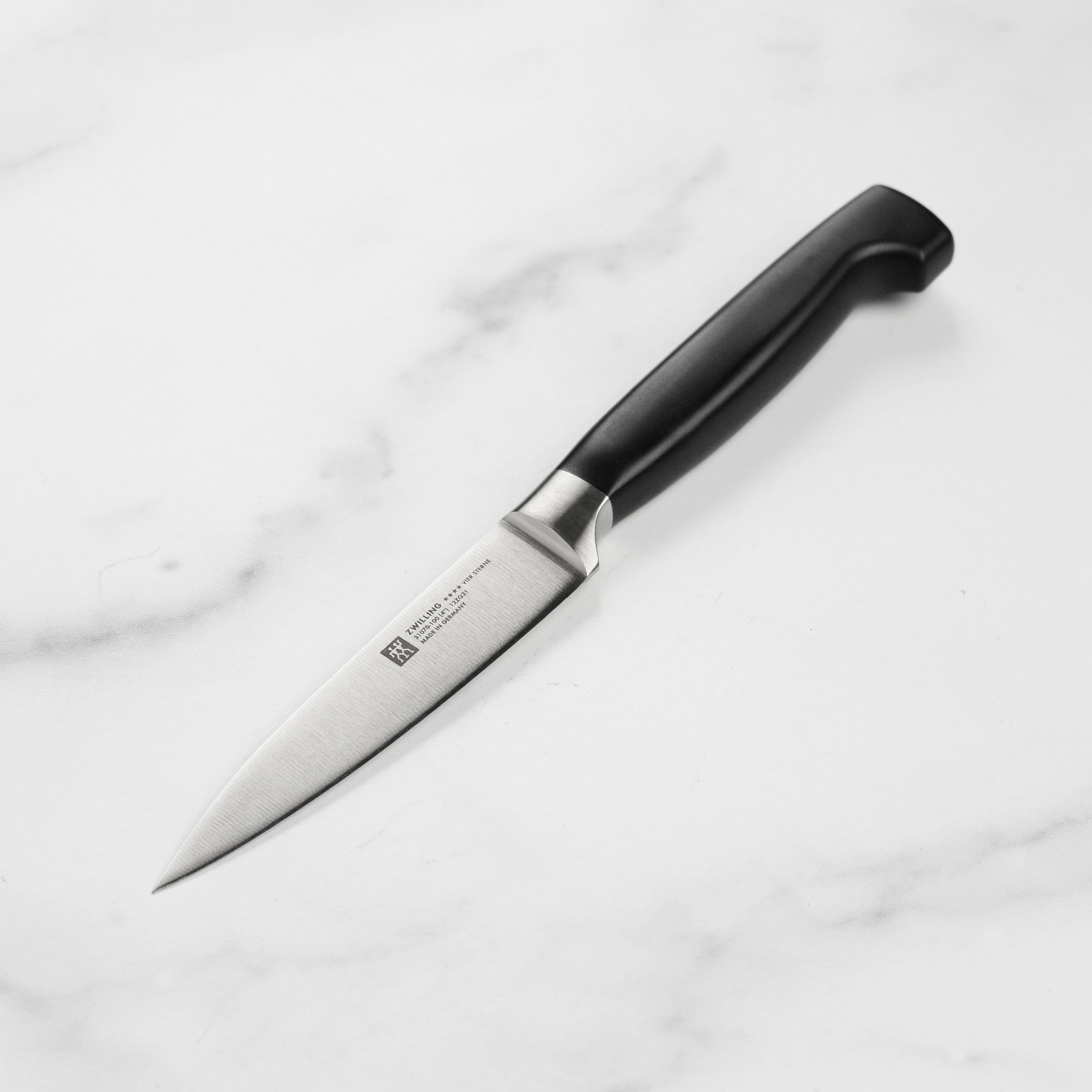 Close-up of Zwilling Four Star paring knife highlighting the precision blade and comfortable grip.