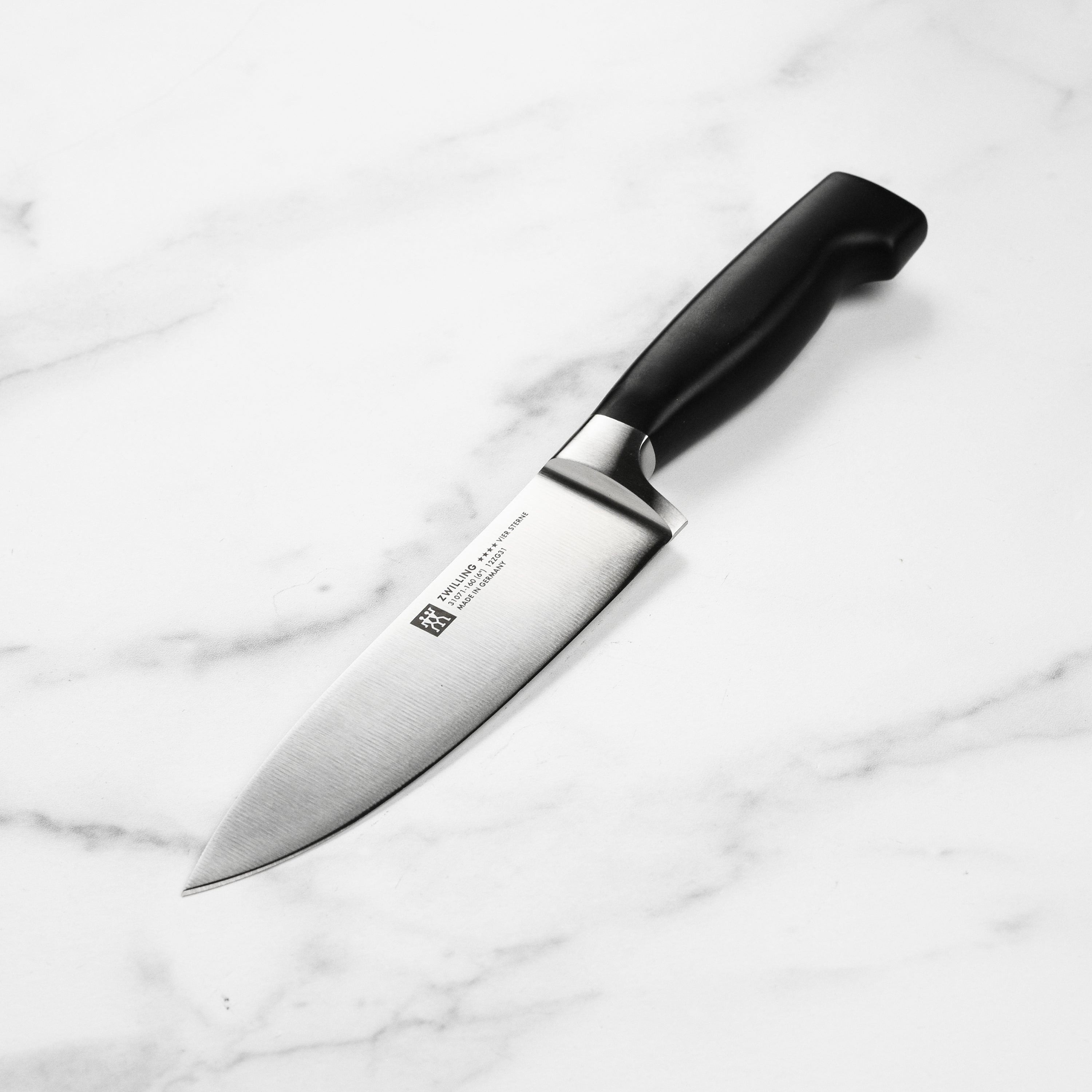 Close-up of the Zwilling Four Star chef's knife highlighting its sharp blade and ergonomic handle.