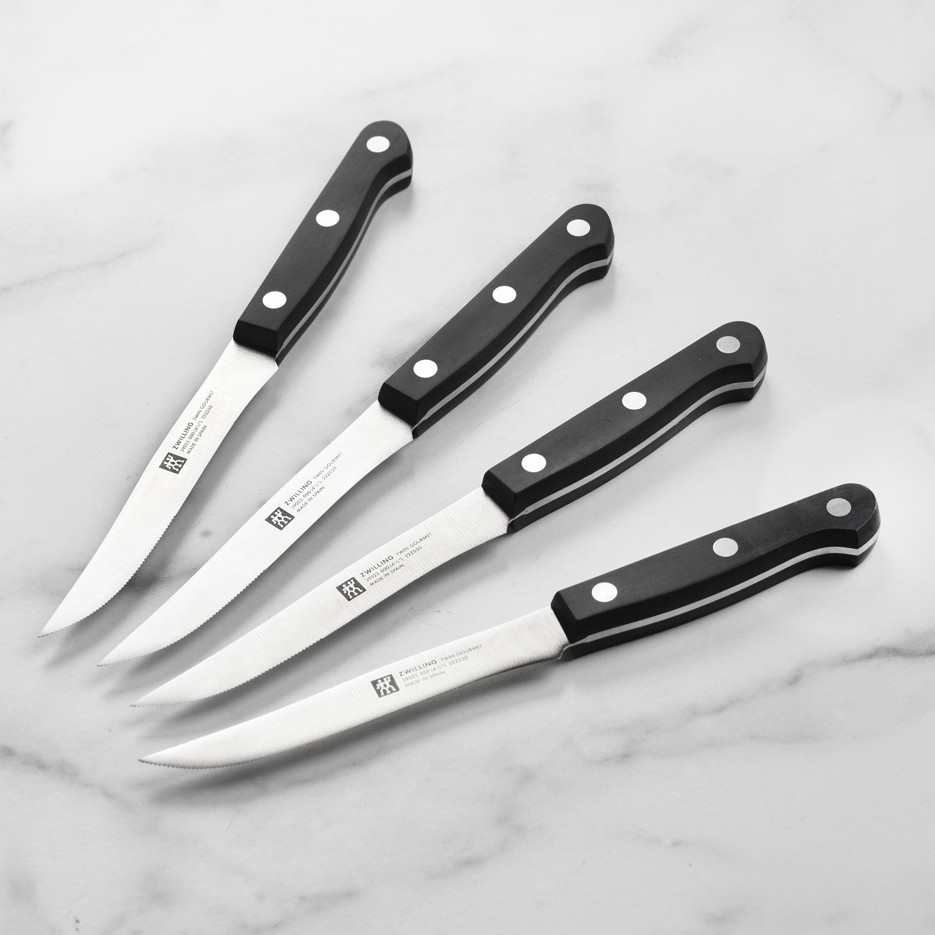 High-carbon stainless steel steak knife from the premium set, showcasing the sharp blade and ergonomic handle.