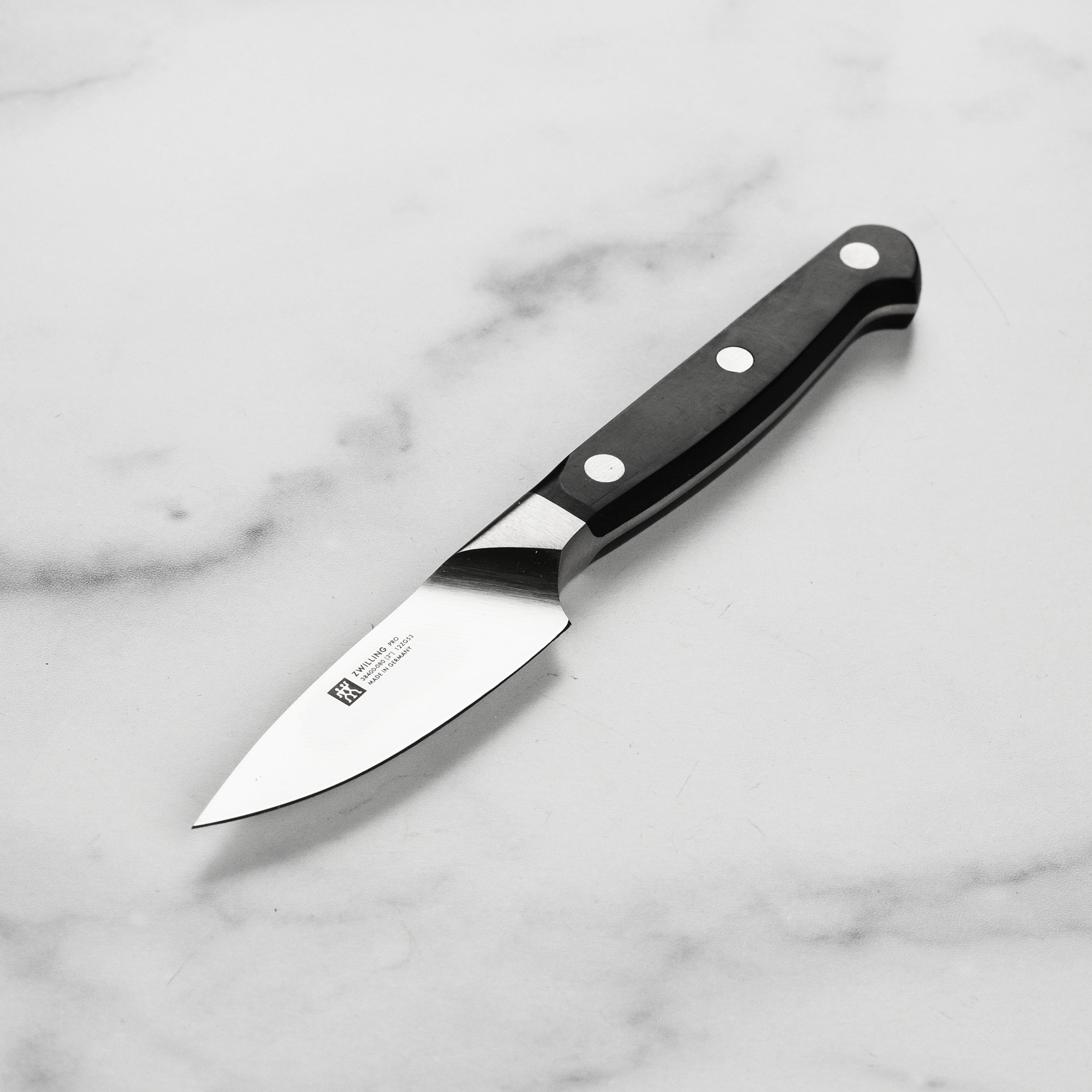 Close-up view of the Zwilling Pro 3-inch paring knife, highlighting its sharp blade and ergonomic handle.