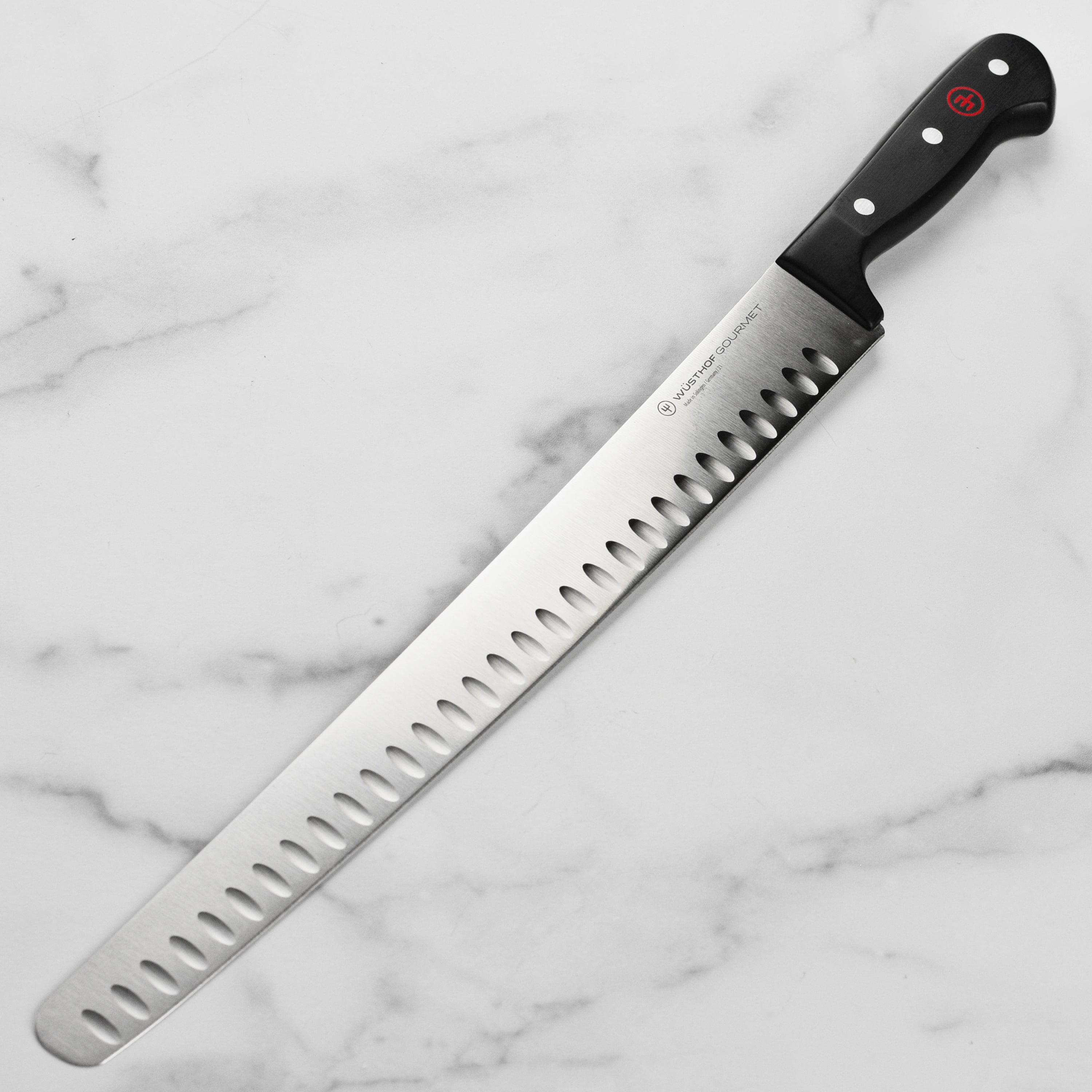 Wusthof Gourmet 14-inch hollow edge brisket slicer on kitchen countertop showcasing its blade and handle