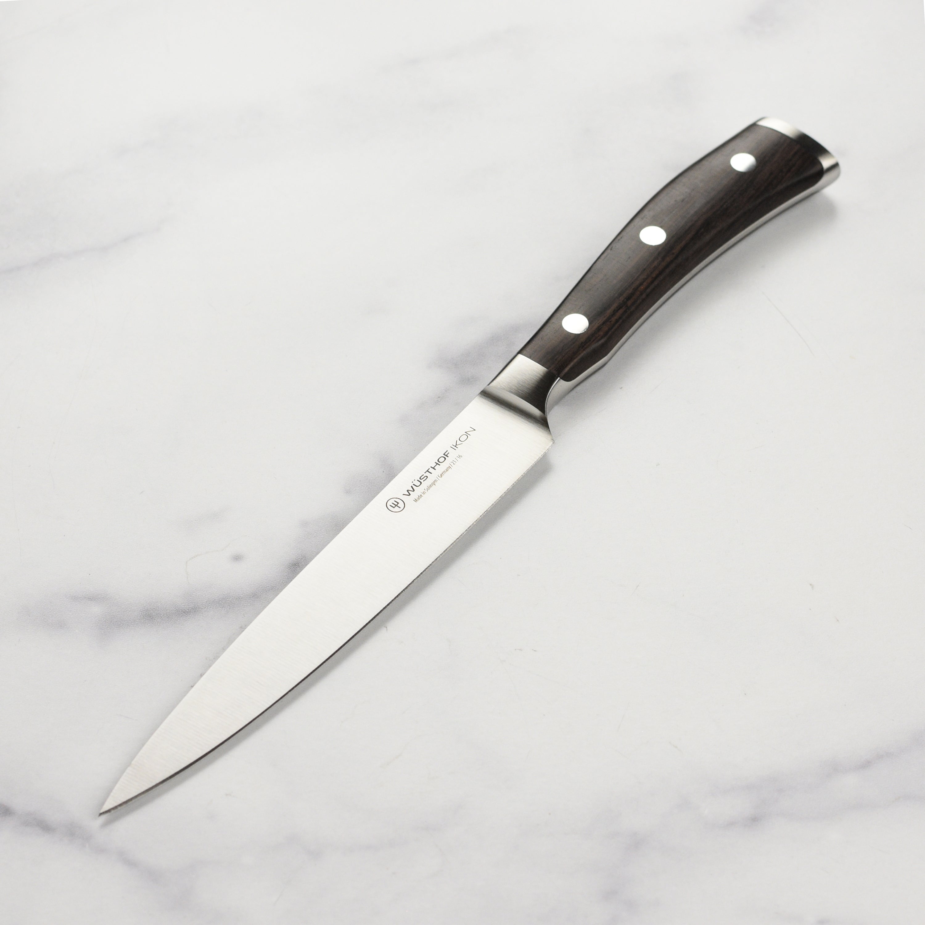 Wusthof Ikon Blackwood utility knife showcasing its sharp edge and elegant handle design.
