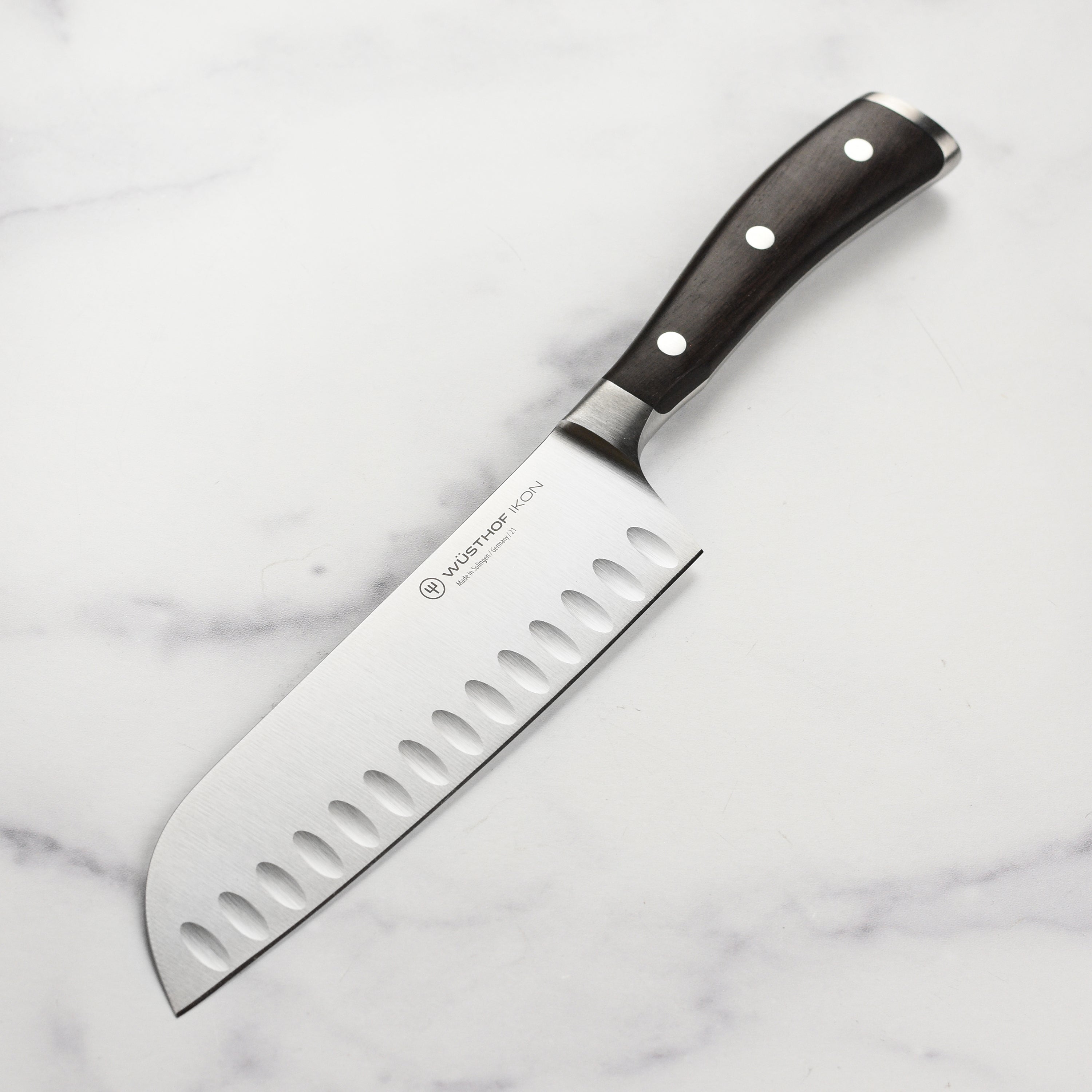 Close-up of the Wusthof Ikon 7 inch Santoku knife highlighting the blade's precision edge technology.