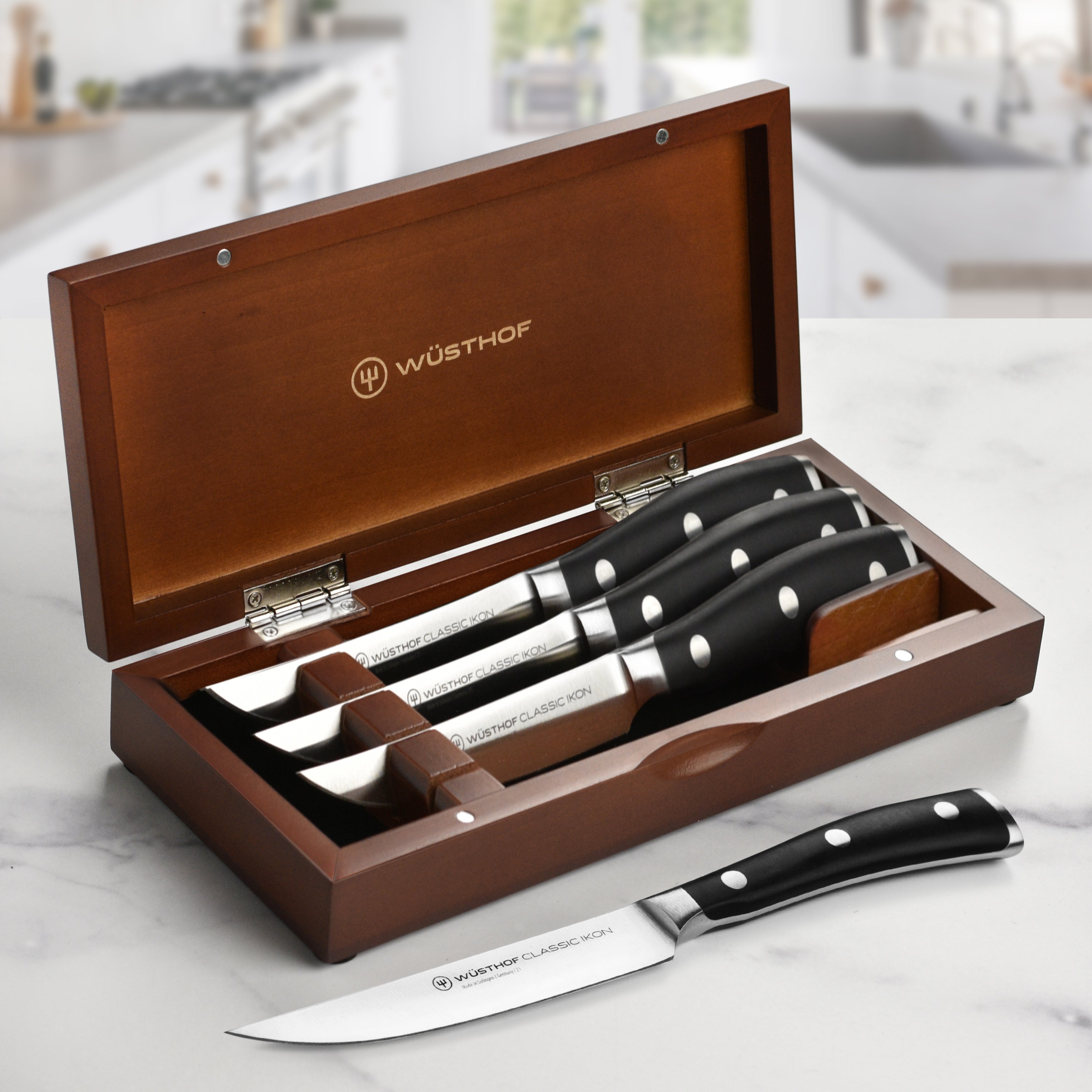 Close-up of high-carbon steel Wusthof knives in walnut wood case
