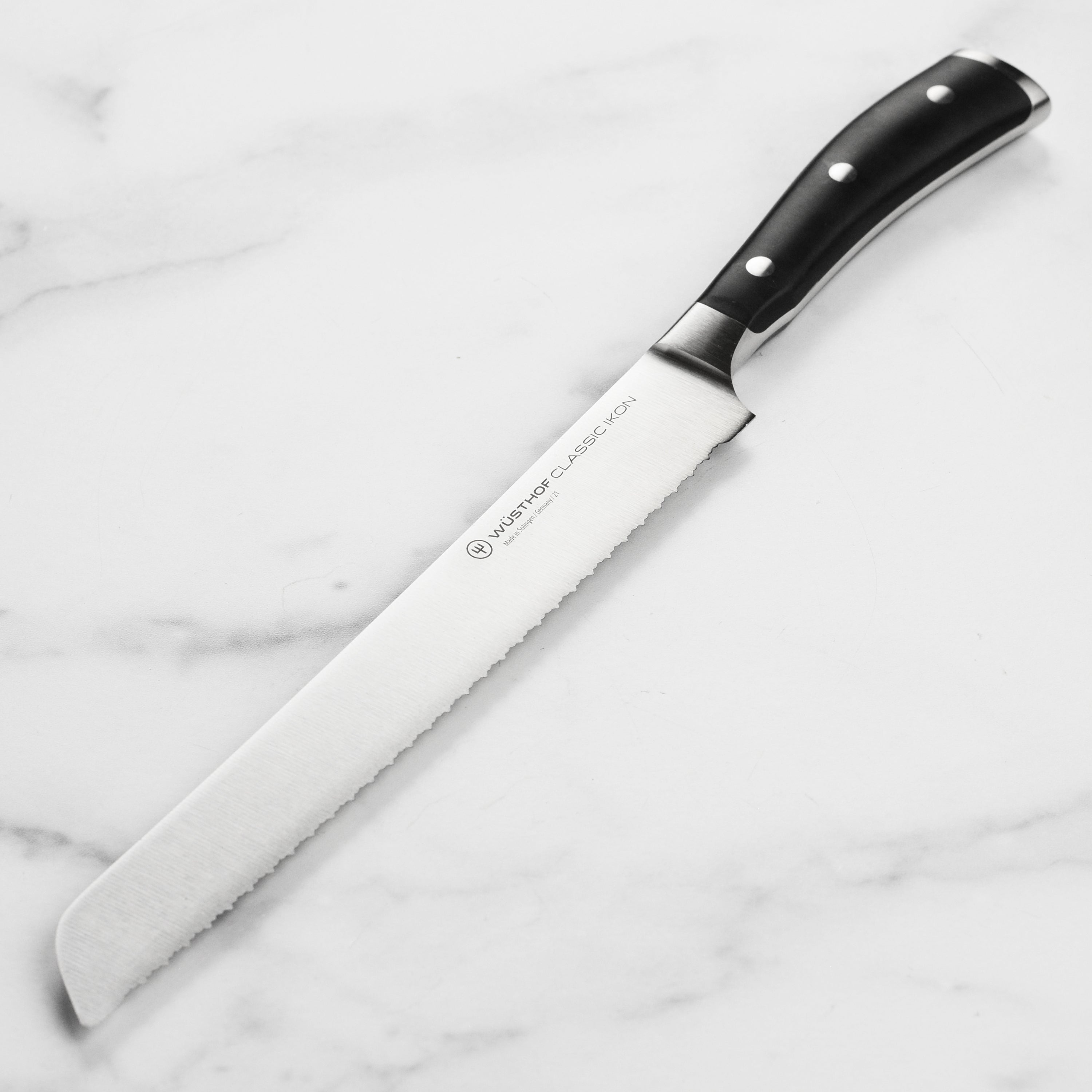 Wusthof Classic Ikon serrated bread knife showcasing the sharp blade and ergonomic handle.