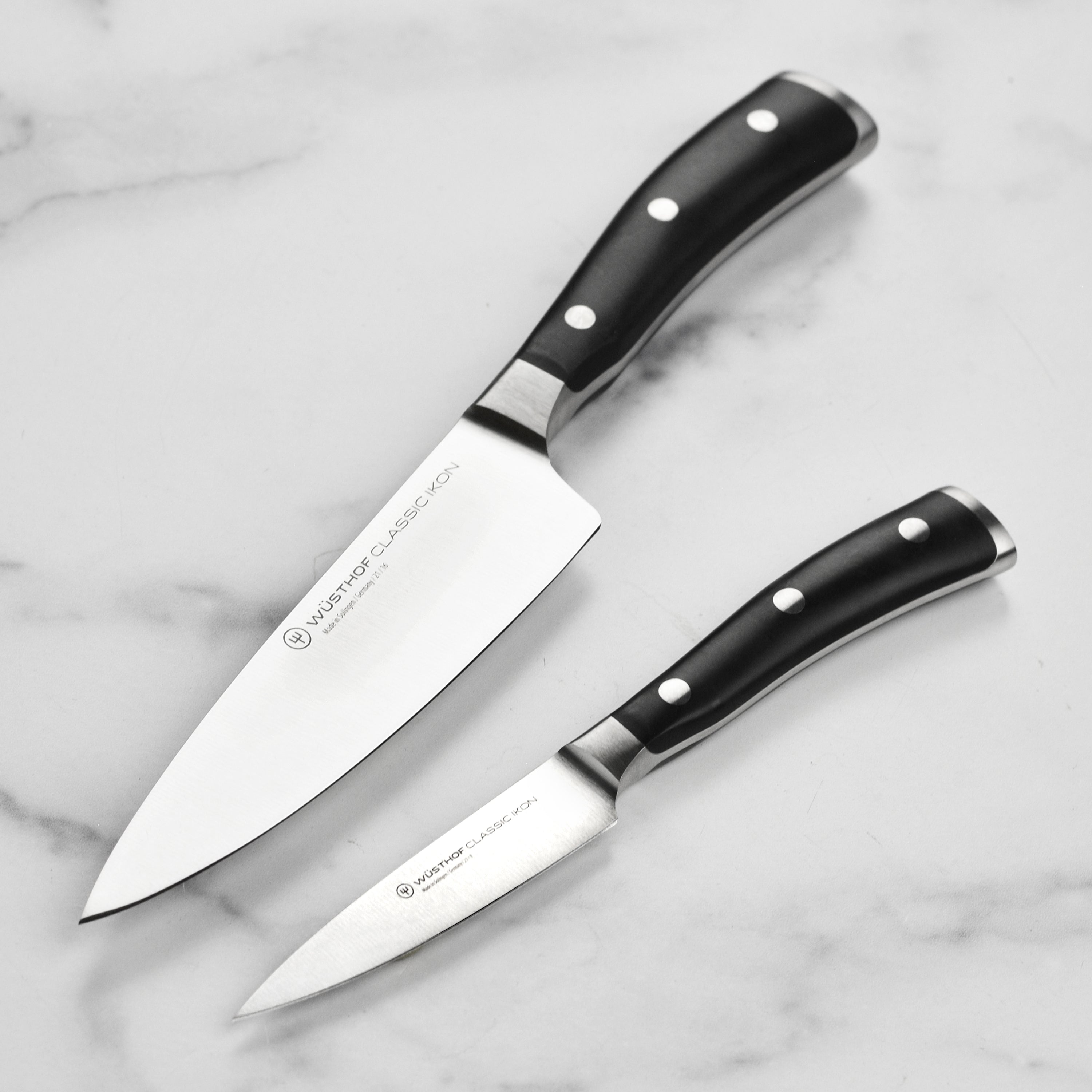 Close-up of Wusthof Classic Ikon chef's knife blade showing sharp edge and high-carbon steel finish