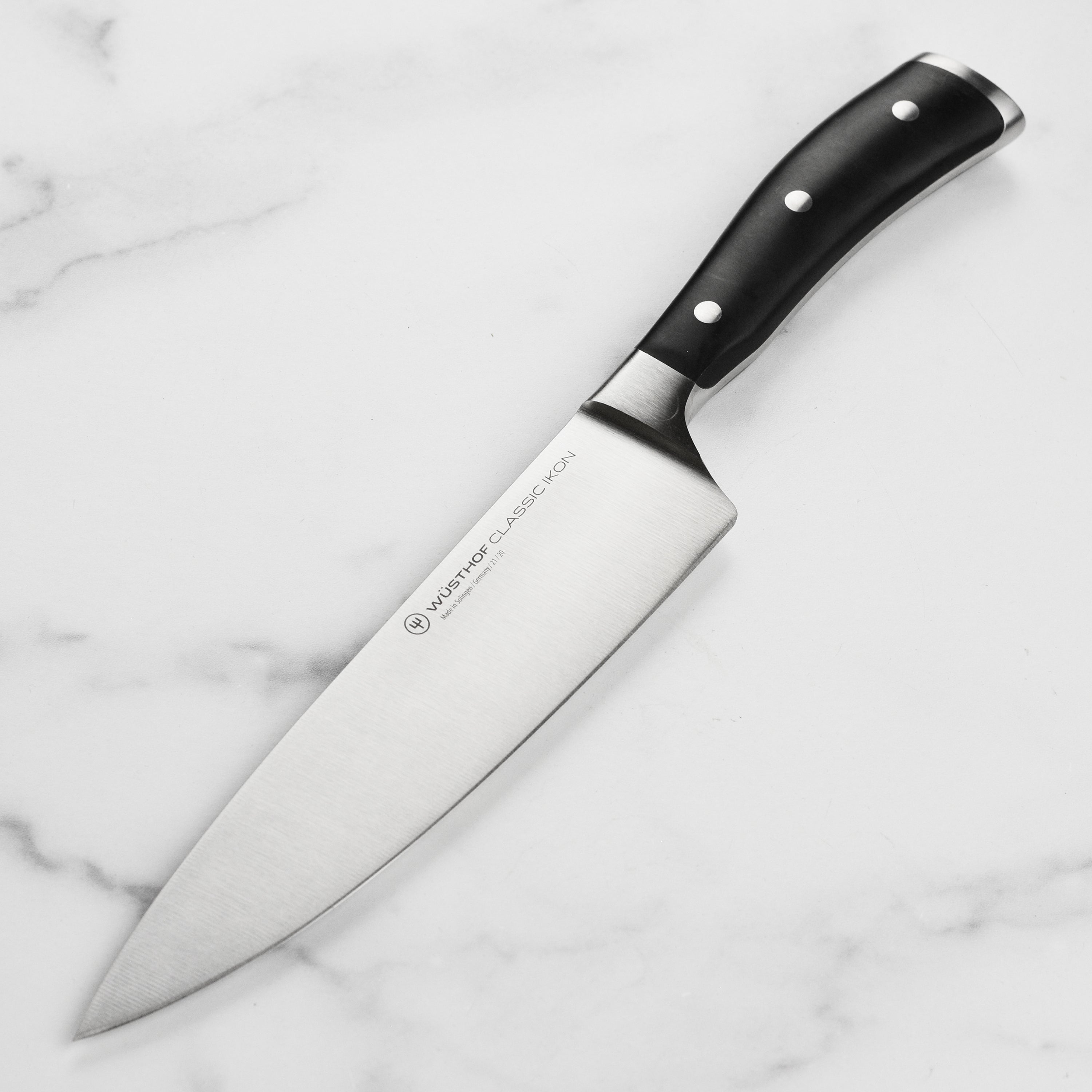 Side view of the Wusthof Classic Ikon chef's knife showcasing its sharp blade and ergonomic handle.