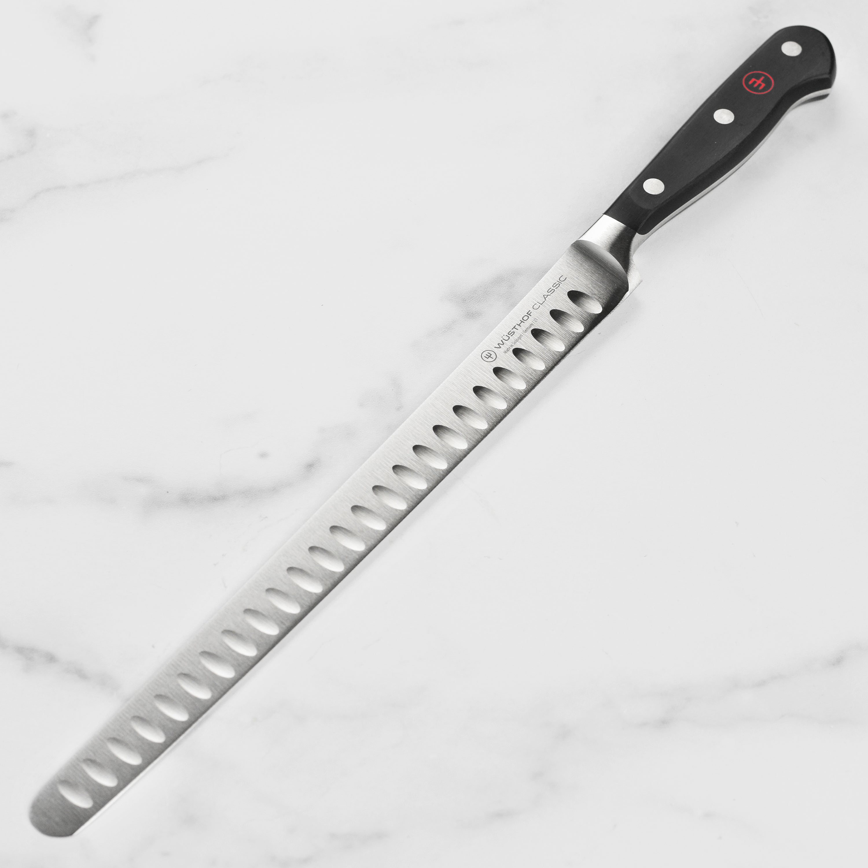 Wusthof Classic 10-inch hollow edge slicing knife with a sharp blade and ergonomic handle from above.