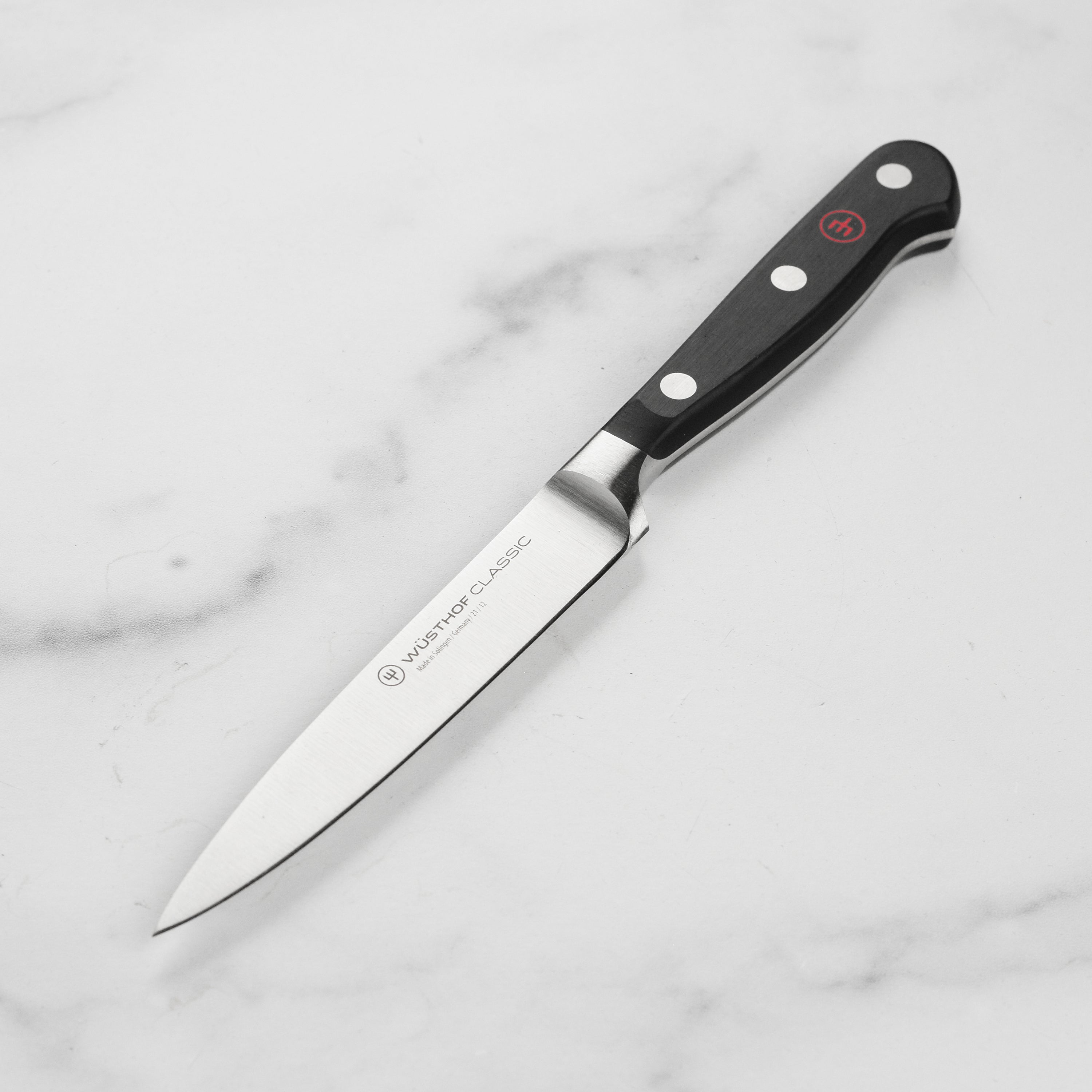 Wusthof Classic utility knife showcasing the sharp blade and ergonomic handle from a side angle.