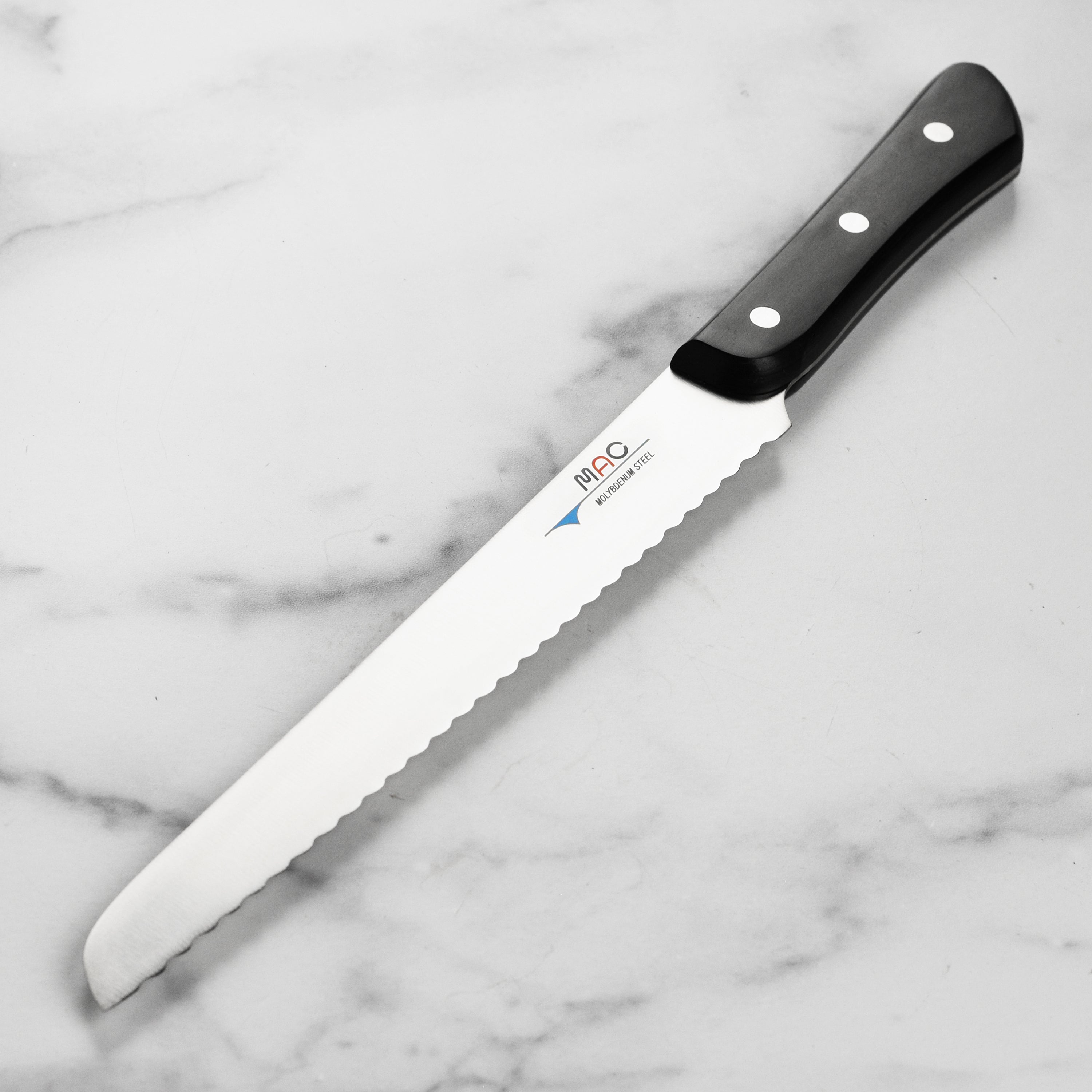 Close-up of the MAC Chef high carbon steel bread knife showcasing its sharp blade and tapered design.