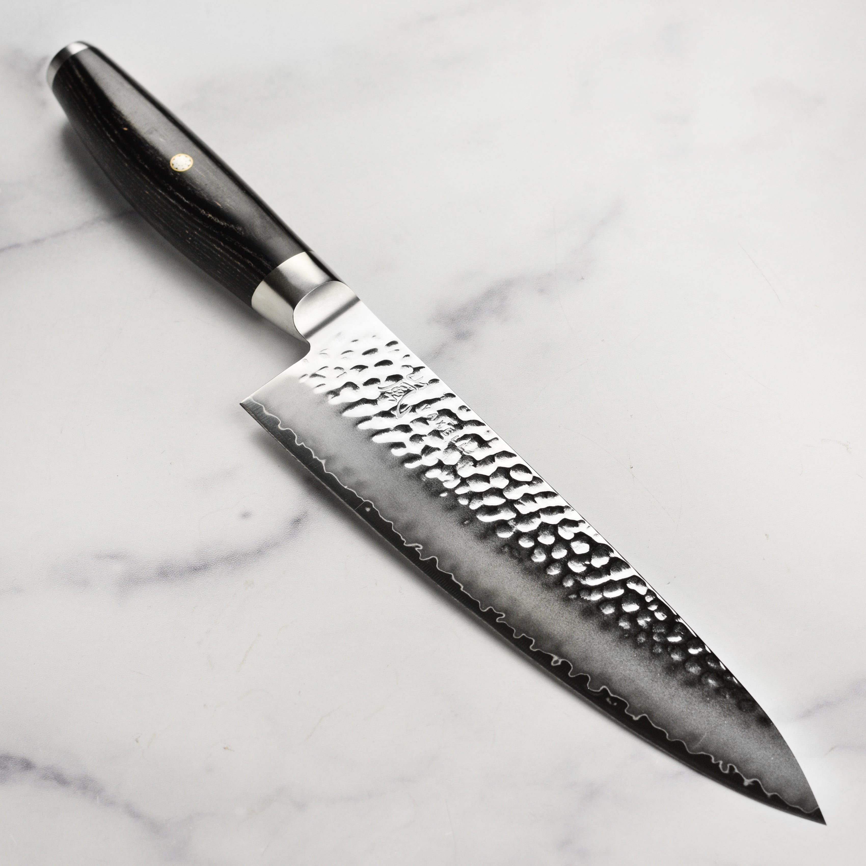 Side view of Yaxell Ketu 8-Inch Chef's Knife showcasing its hammered blade.