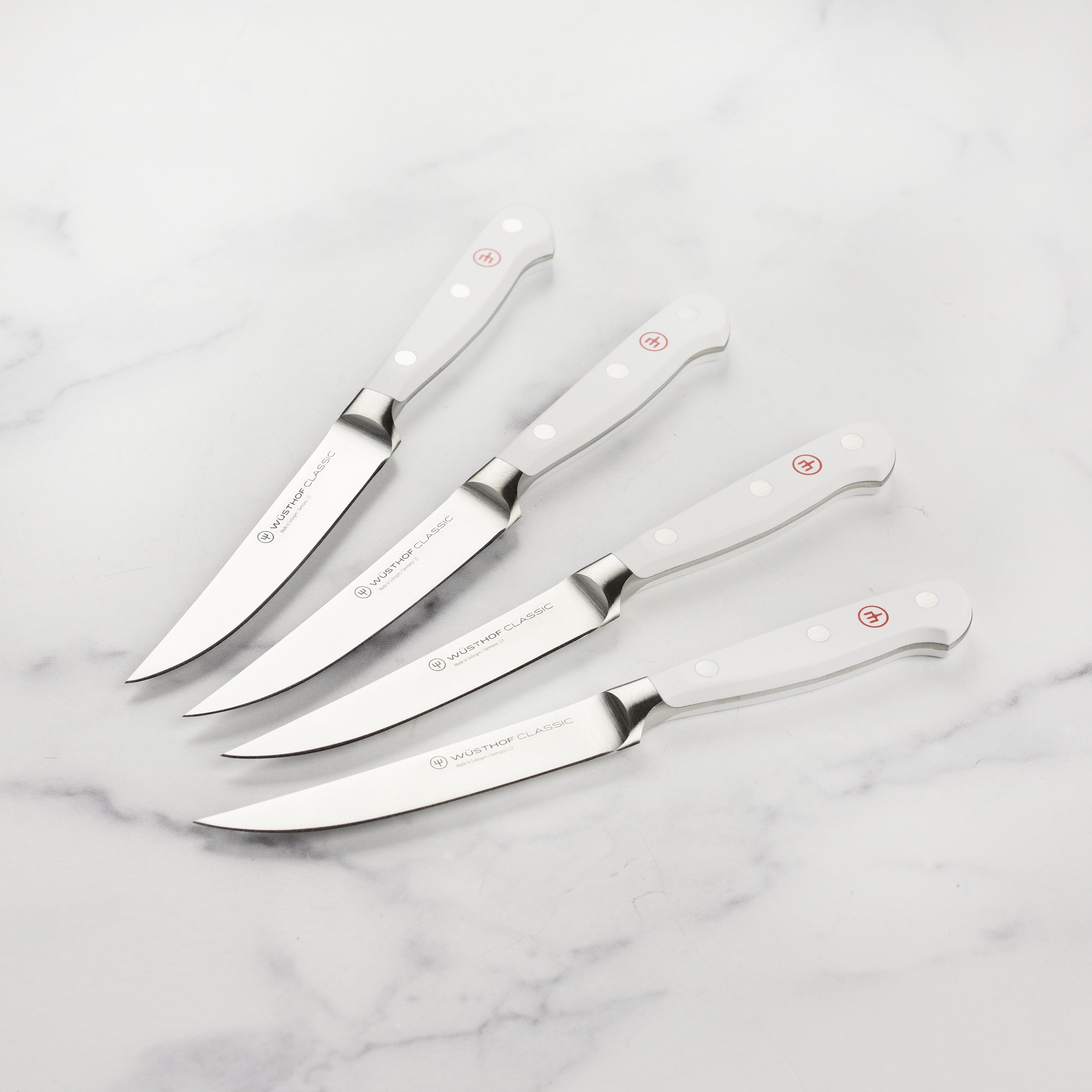 Wusthof Classic steak knife set on a wooden table with a beautifully cooked steak