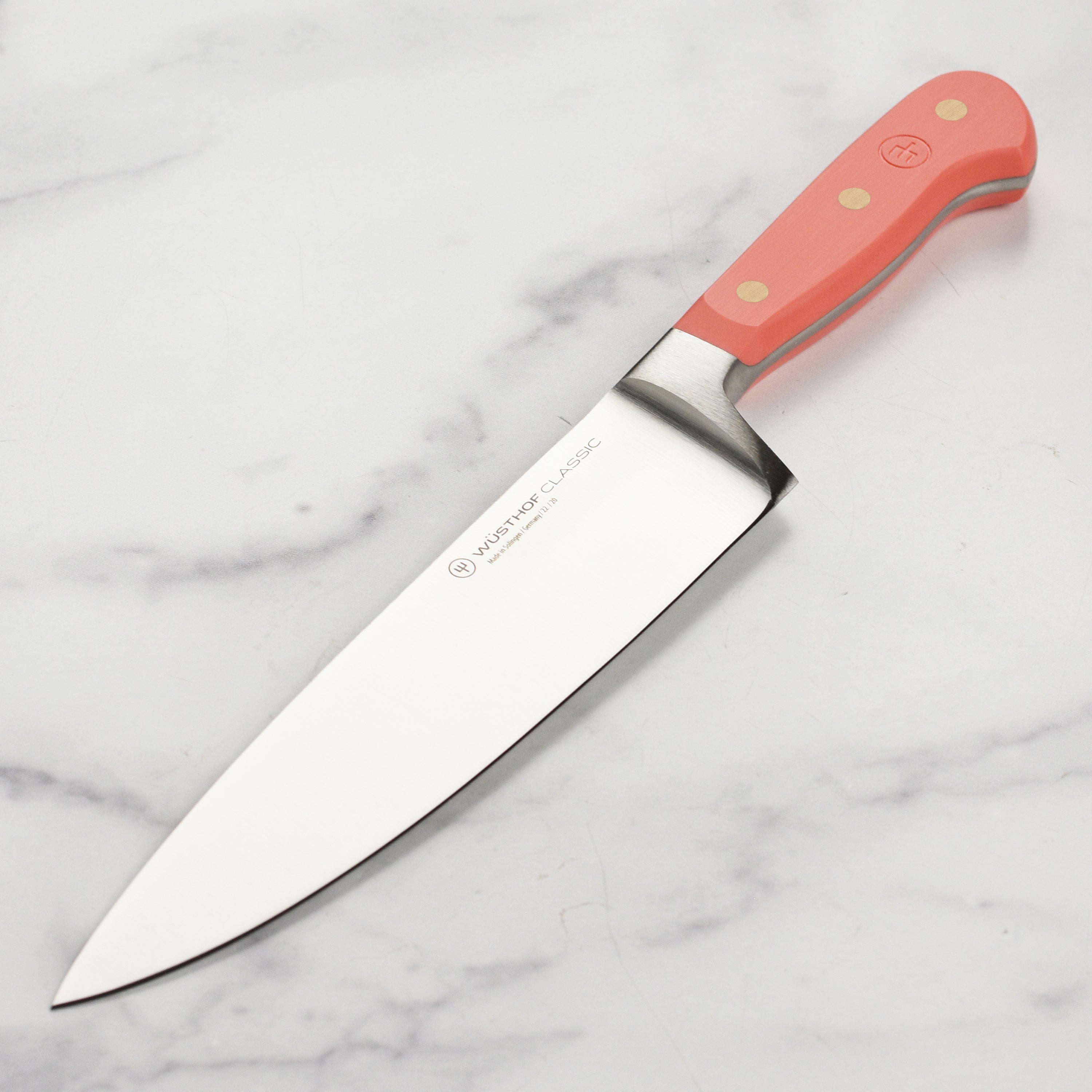 Wusthof Coral Peach Classic 8-Inch Chef's Knife from above, showcasing the sharp blade and ergonomic handle.