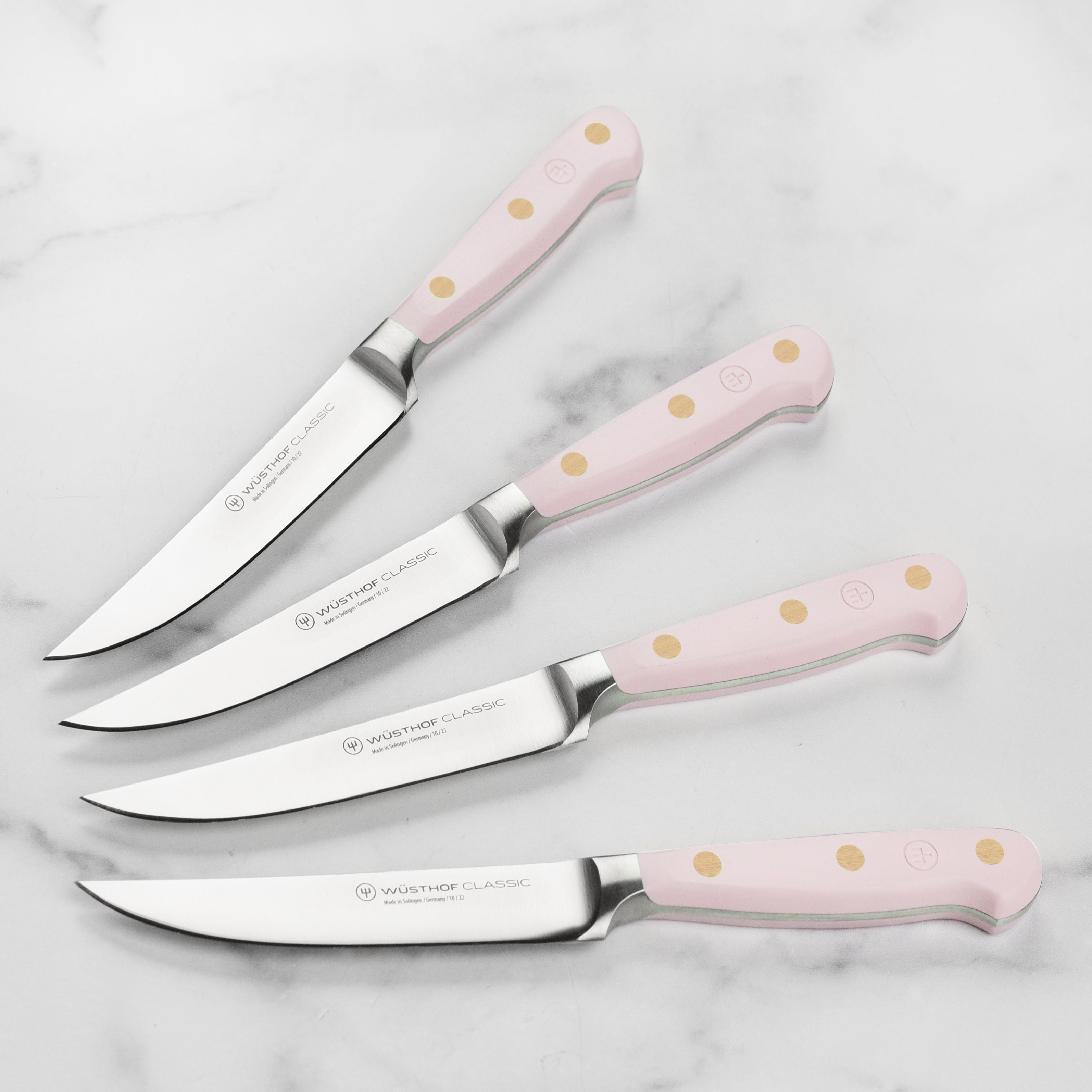 Close-up of pink Himalayan salt steak knives with sharp blades and stylish handles