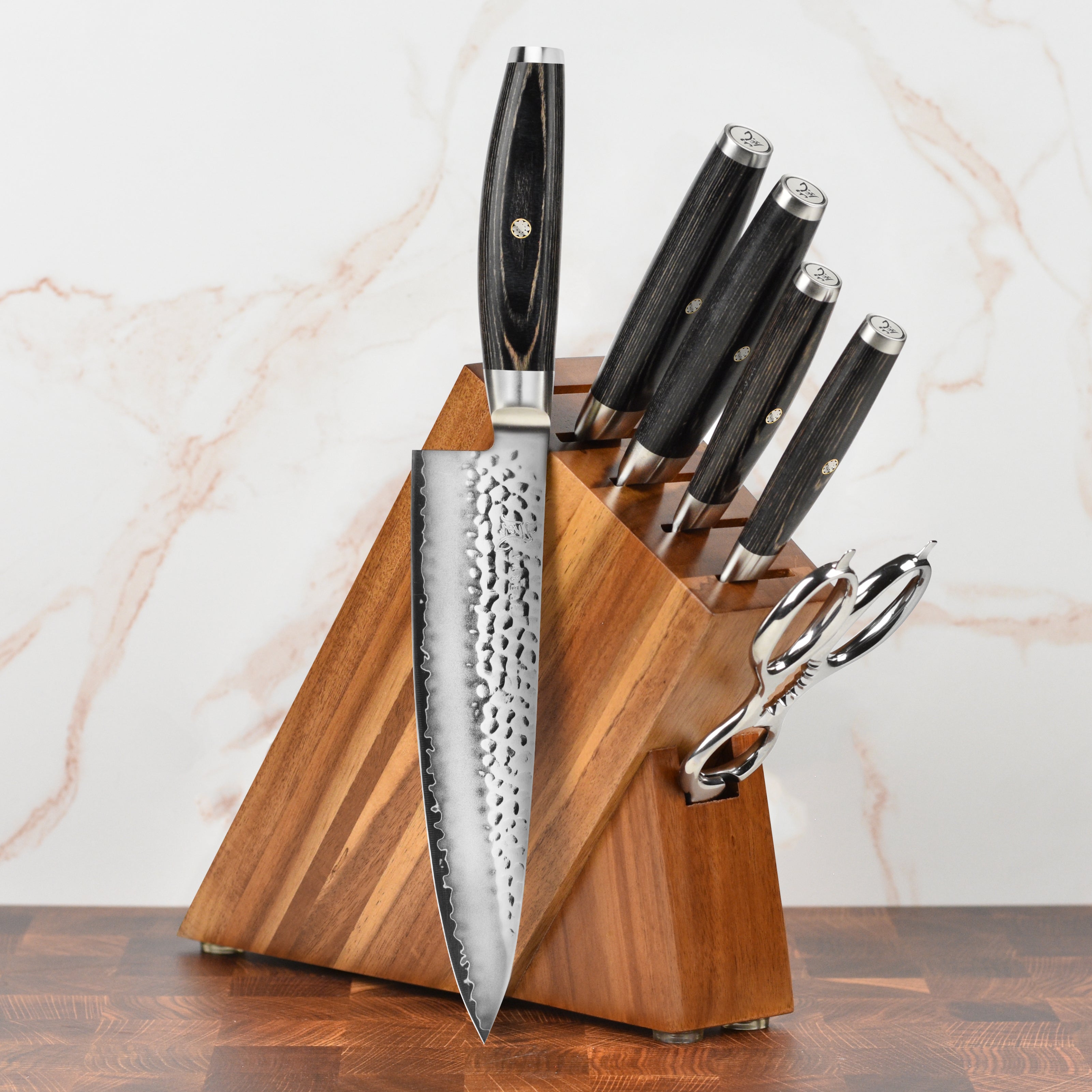 Close-up of Yaxell Ketu Japanese chef knives with hammered finish and ergonomic handles