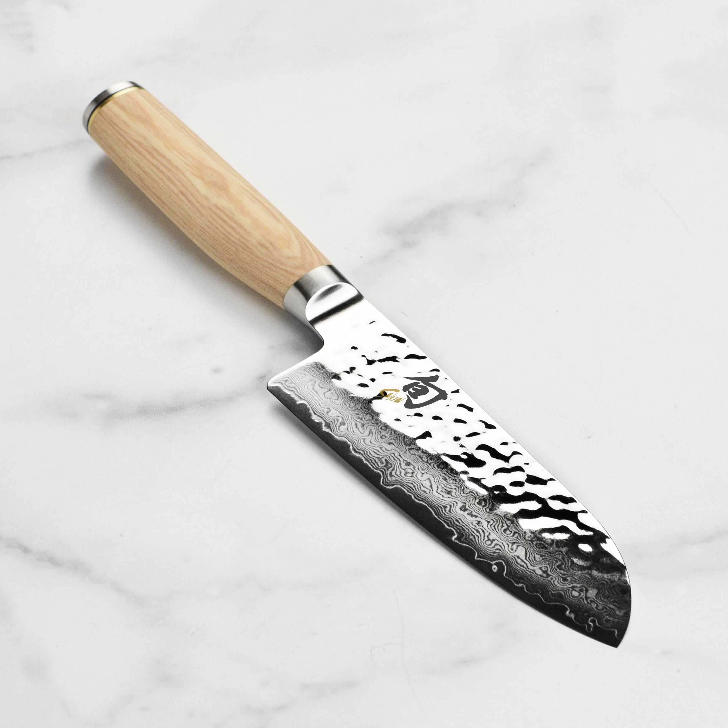 Close-up view of Shun Premier Blonde Santoku knife highlighting the Damascus blade.