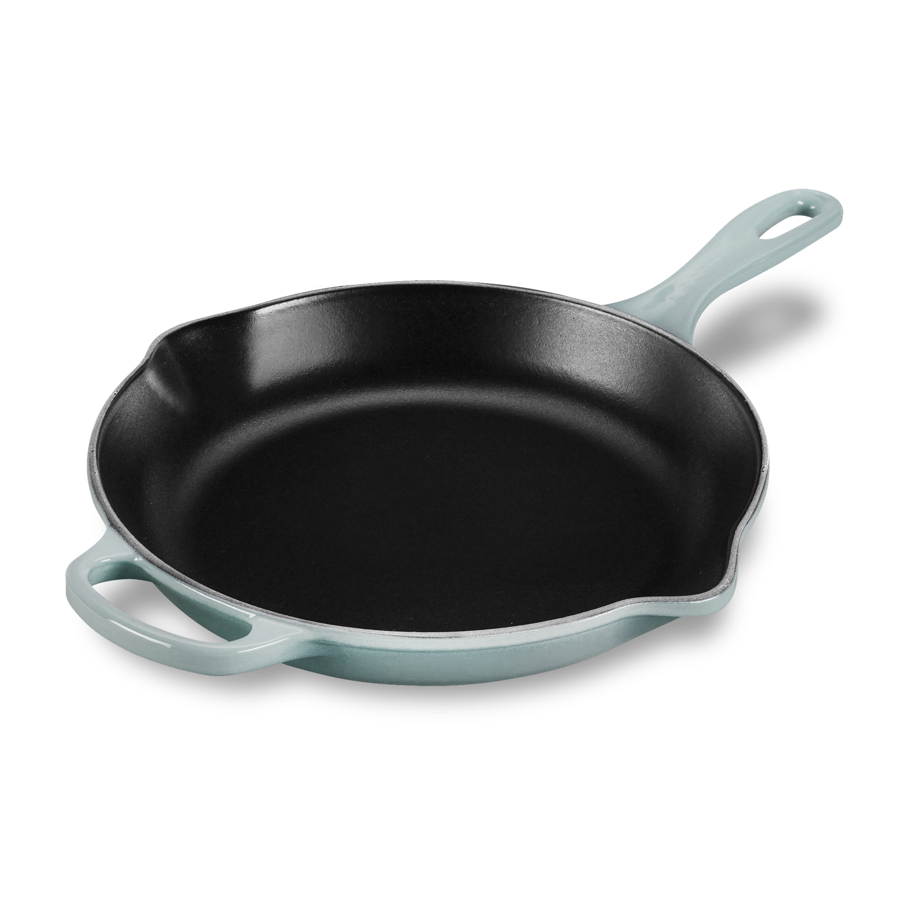 Le Creuset enameled cast iron skillet from a top angle, showcasing its sea salt finish and ergonomic handle.