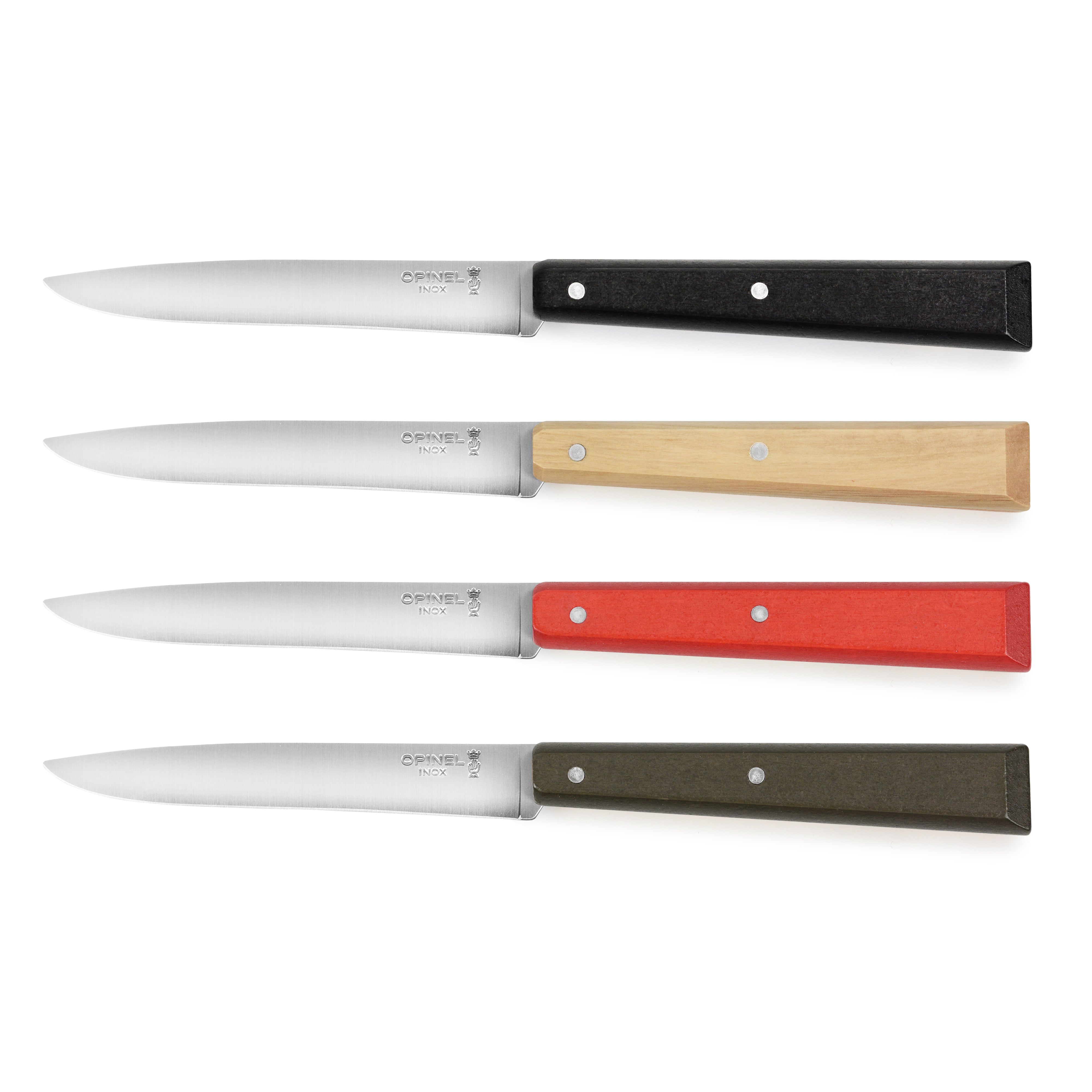 Colorful Opinel steak knives with wooden handles on a dining table.