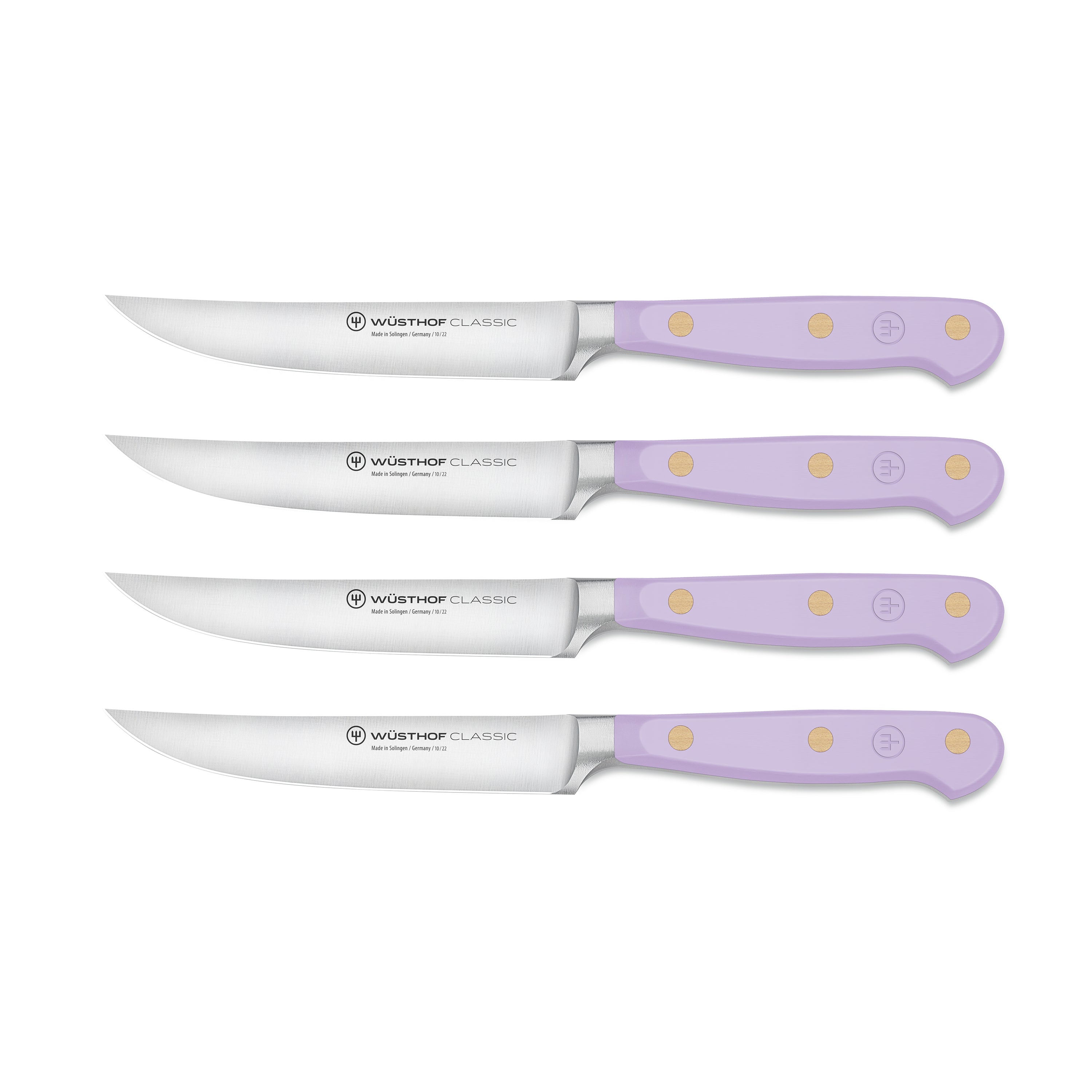 Close-up of Wusthof knives with purple yam handles resting beside grilled steak