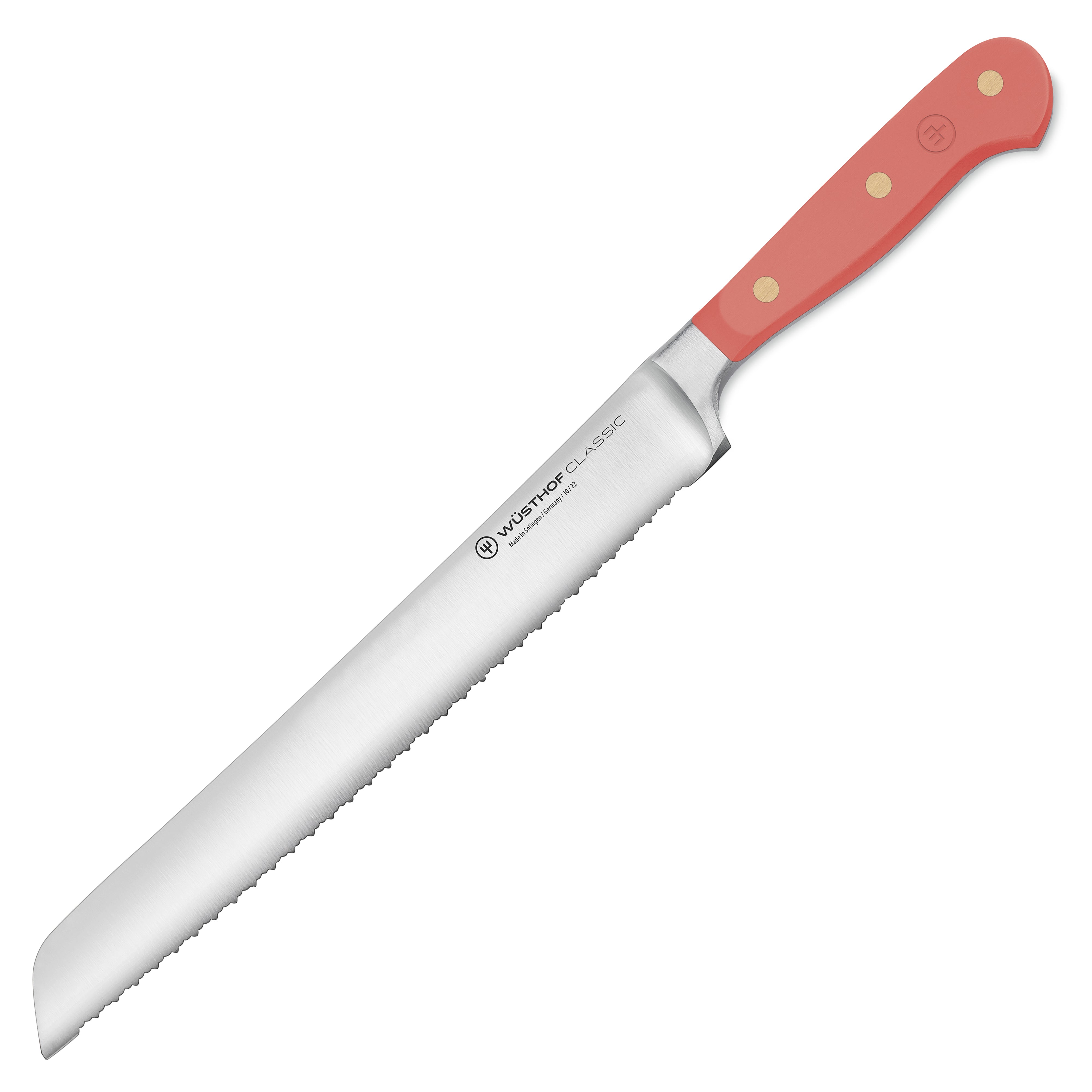 Wusthof Classic 9" Serrated Bread Knife in Coral Peach being used to slice a crusty loaf of bread.