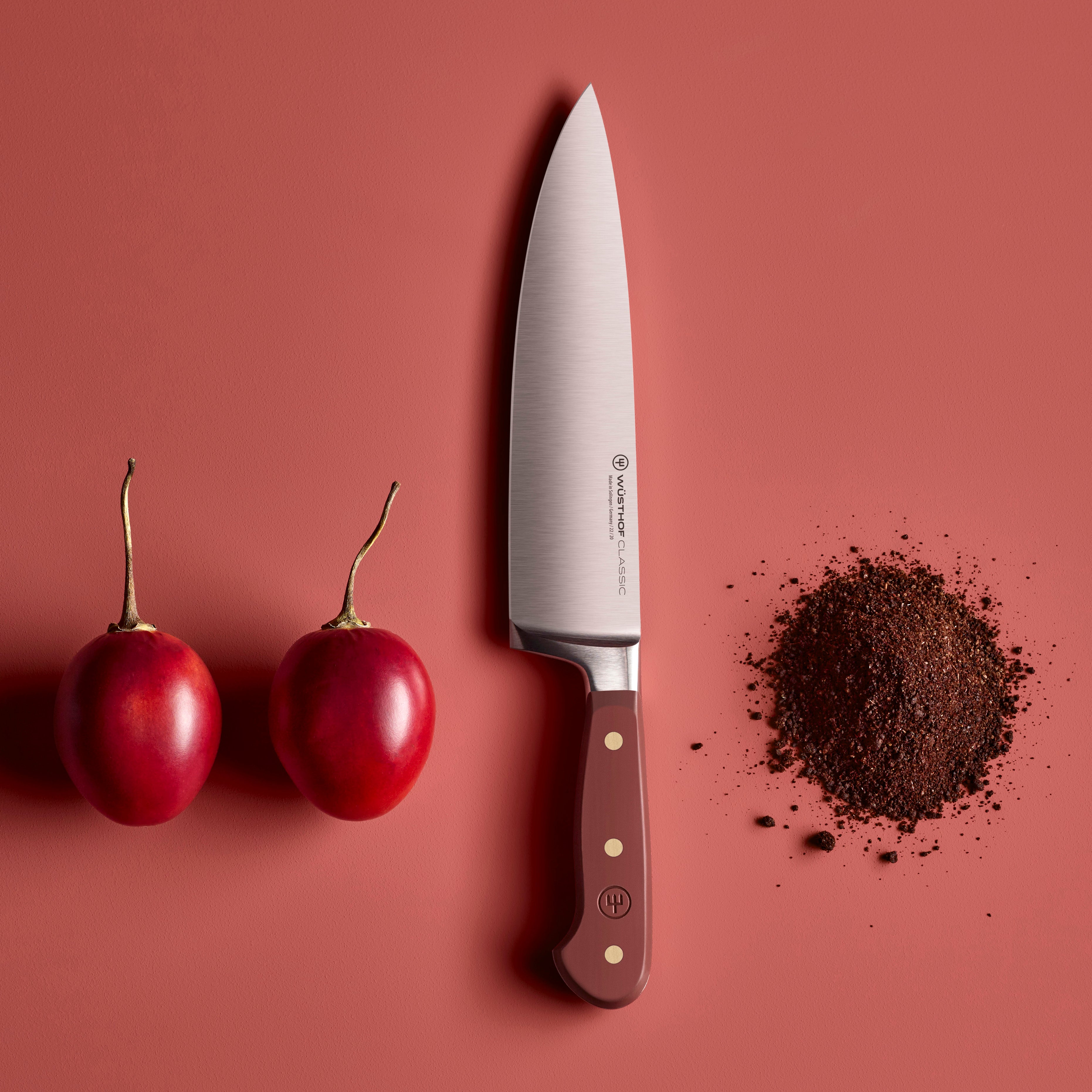 Wusthof Classic Chefs Knife on a cutting board, demonstrating its perfect balance and ergonomic design.