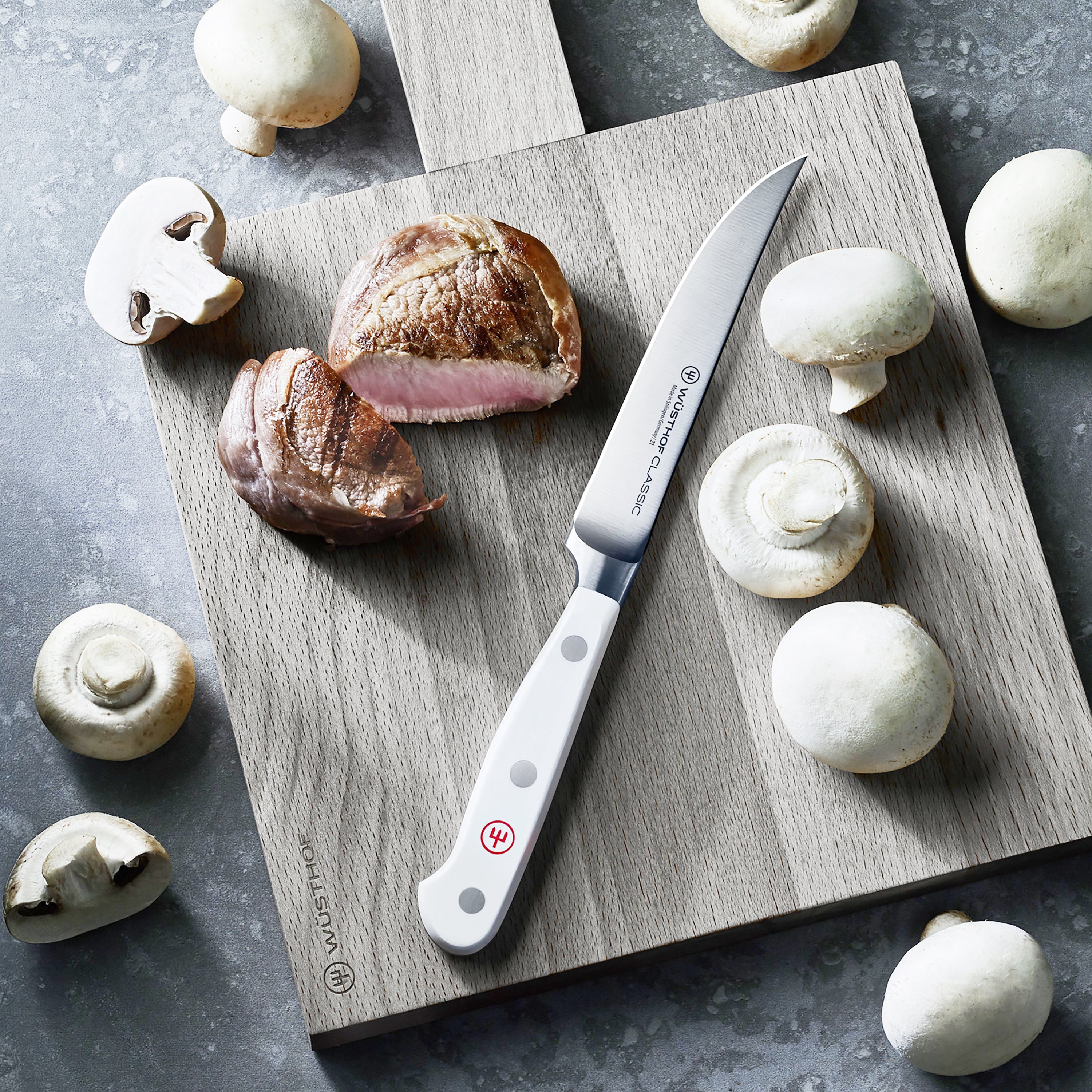 Close-up of the Wusthof Classic steak knife handle, highlighting the triple-riveted POM material.